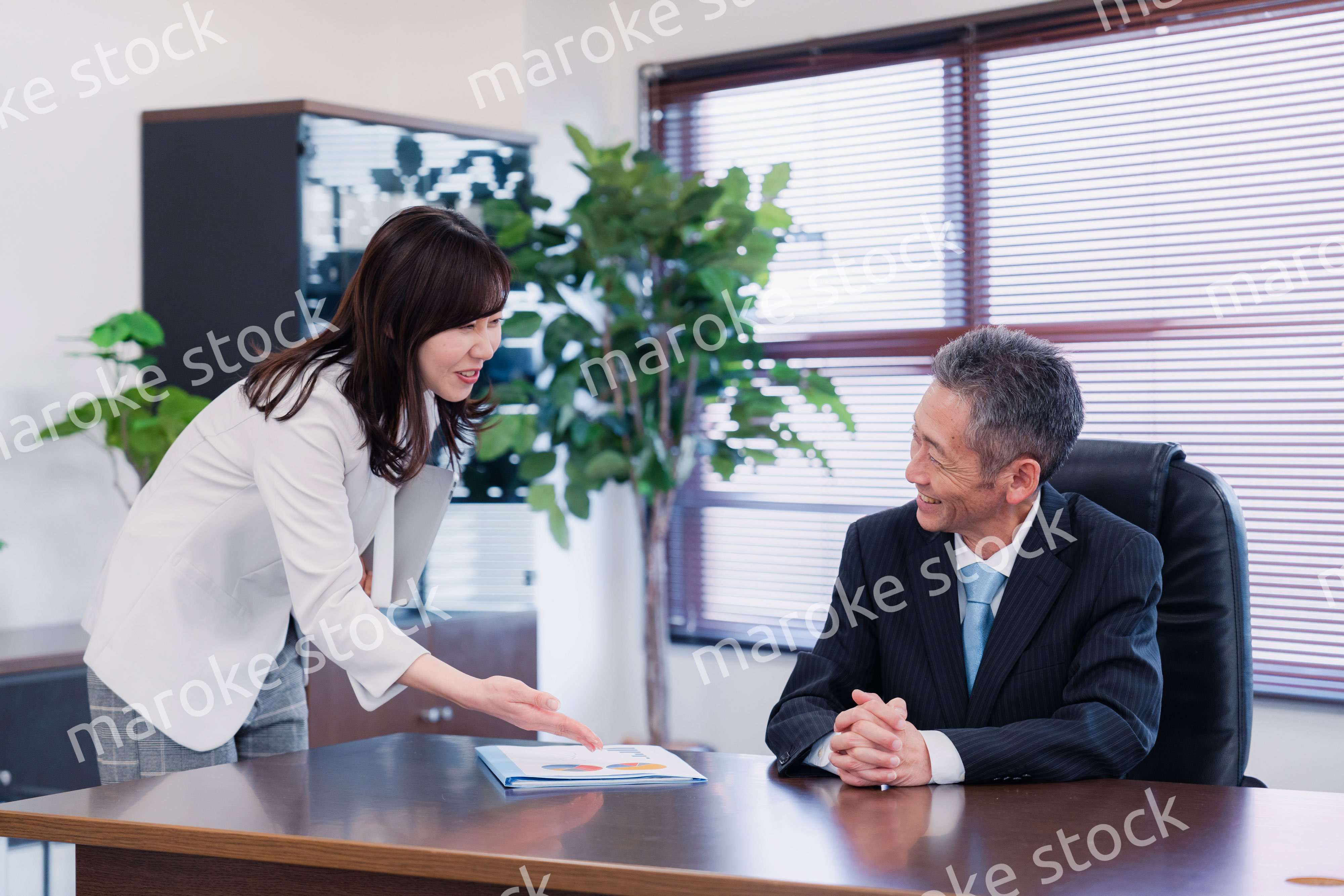 役員に報告をする秘書の女性