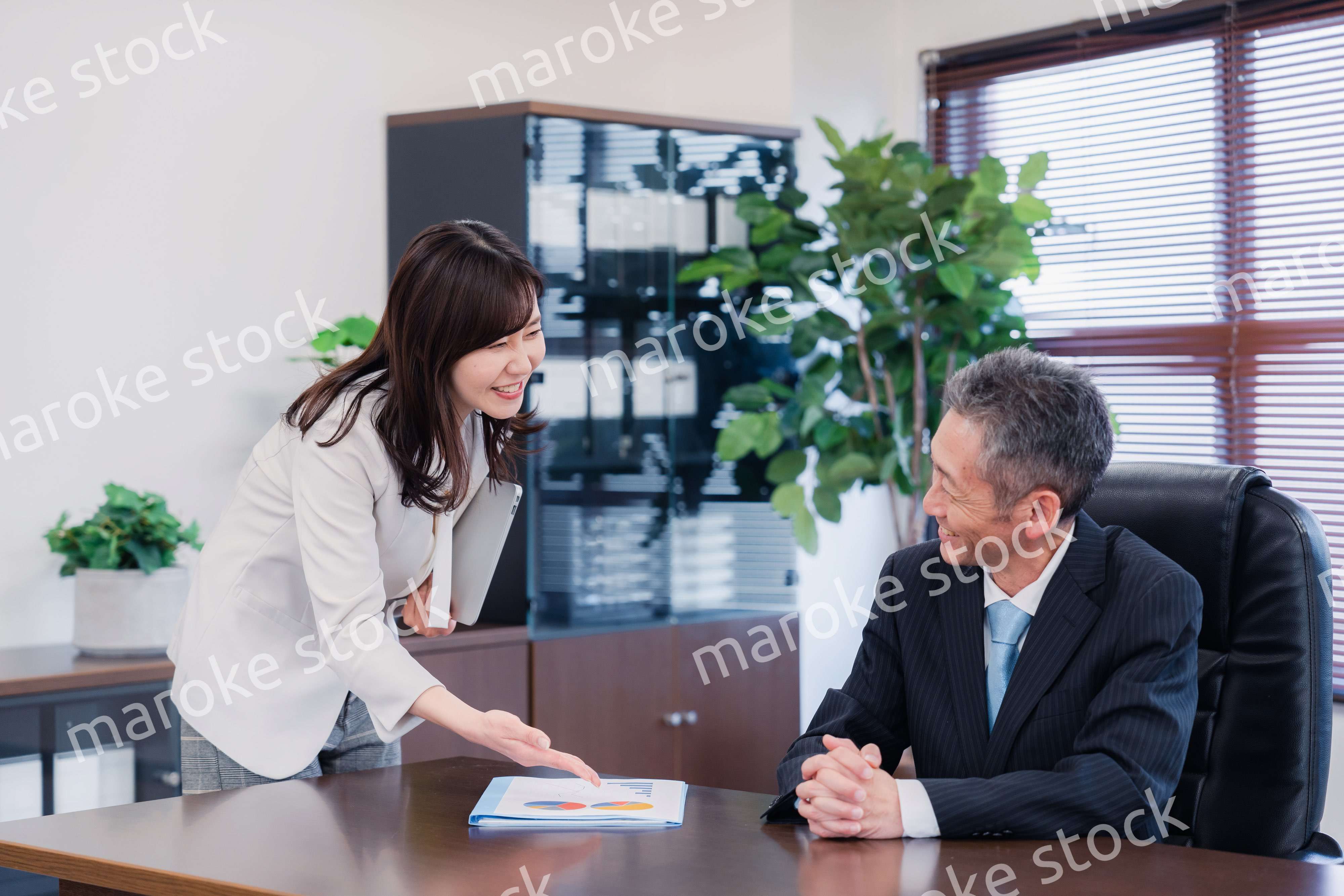 役員に報告をする秘書の女性