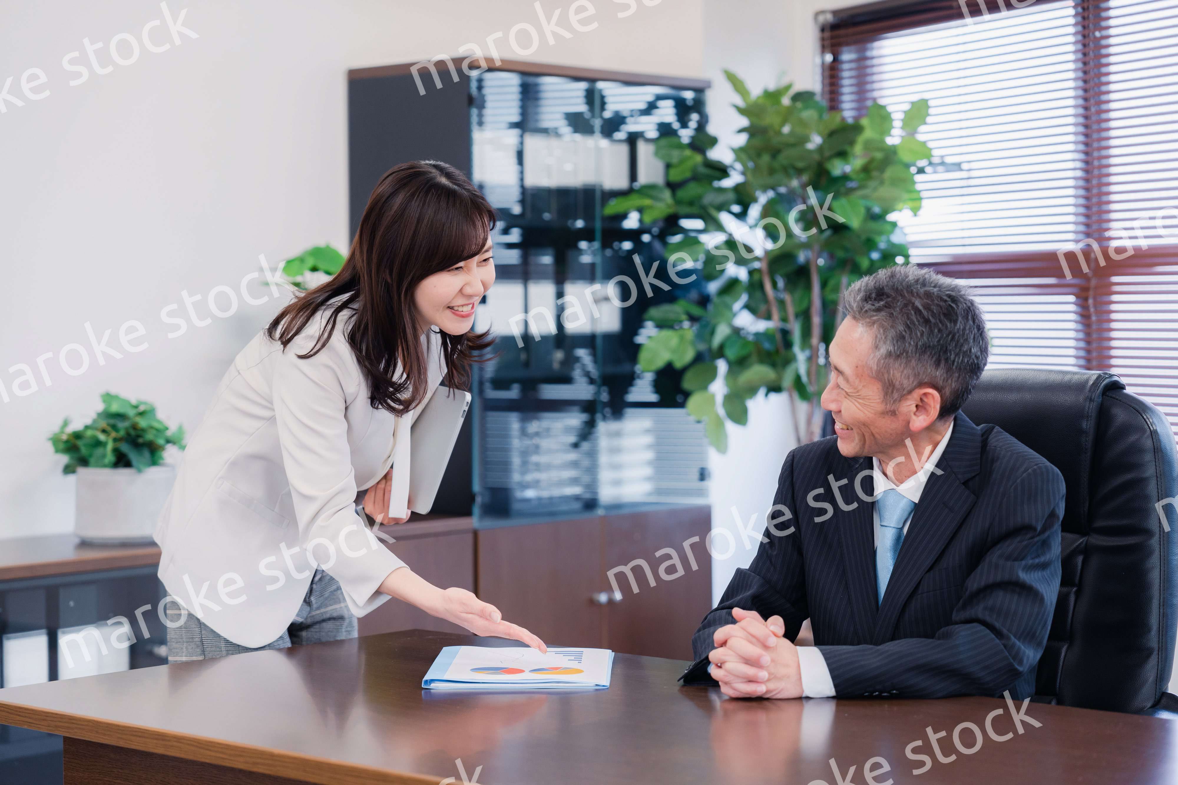 役員に報告をする秘書の女性