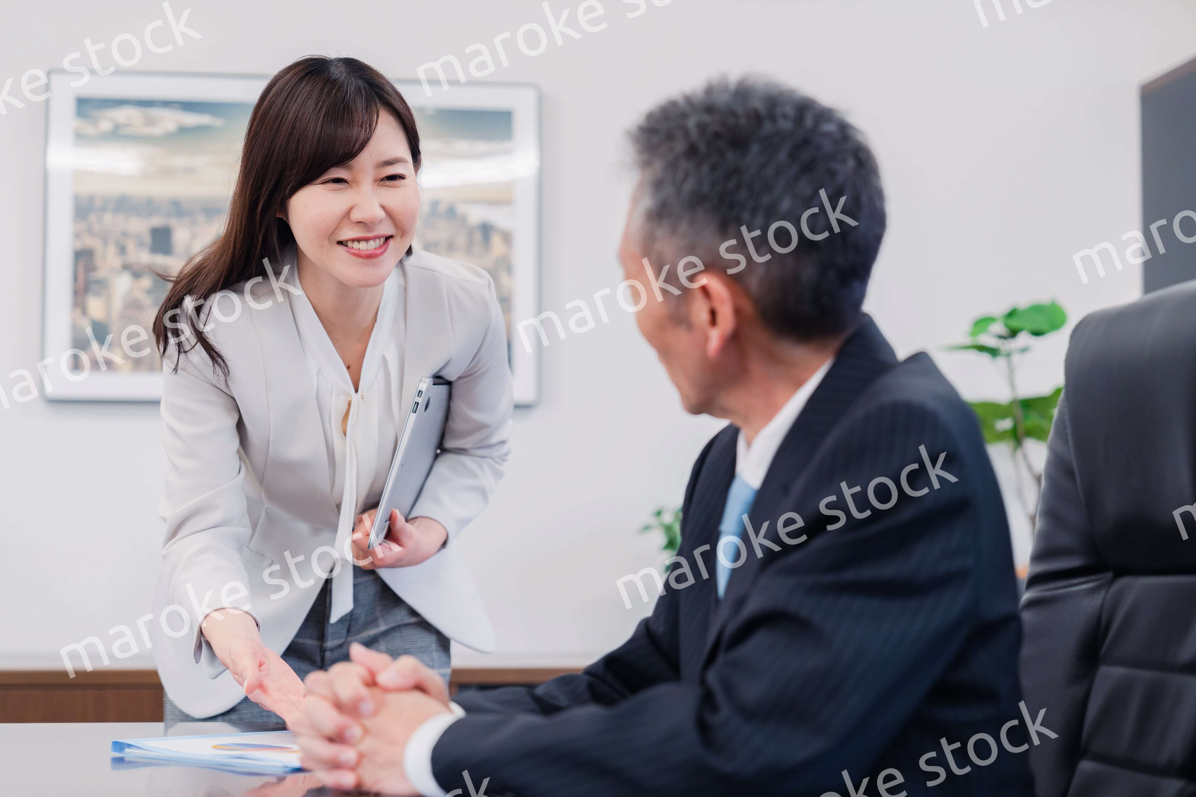 役員に報告をする秘書の女性