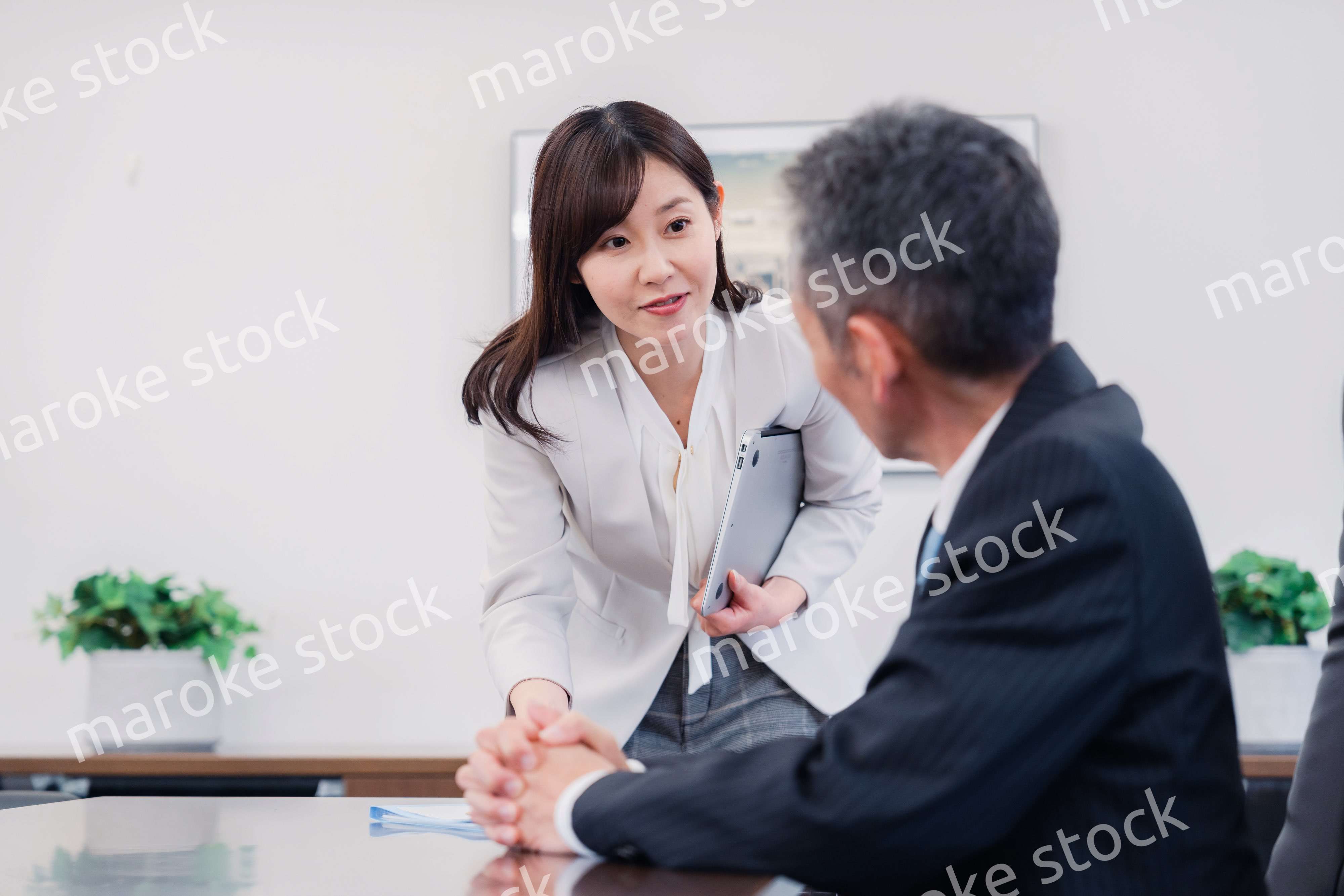 役員に報告をする秘書の女性