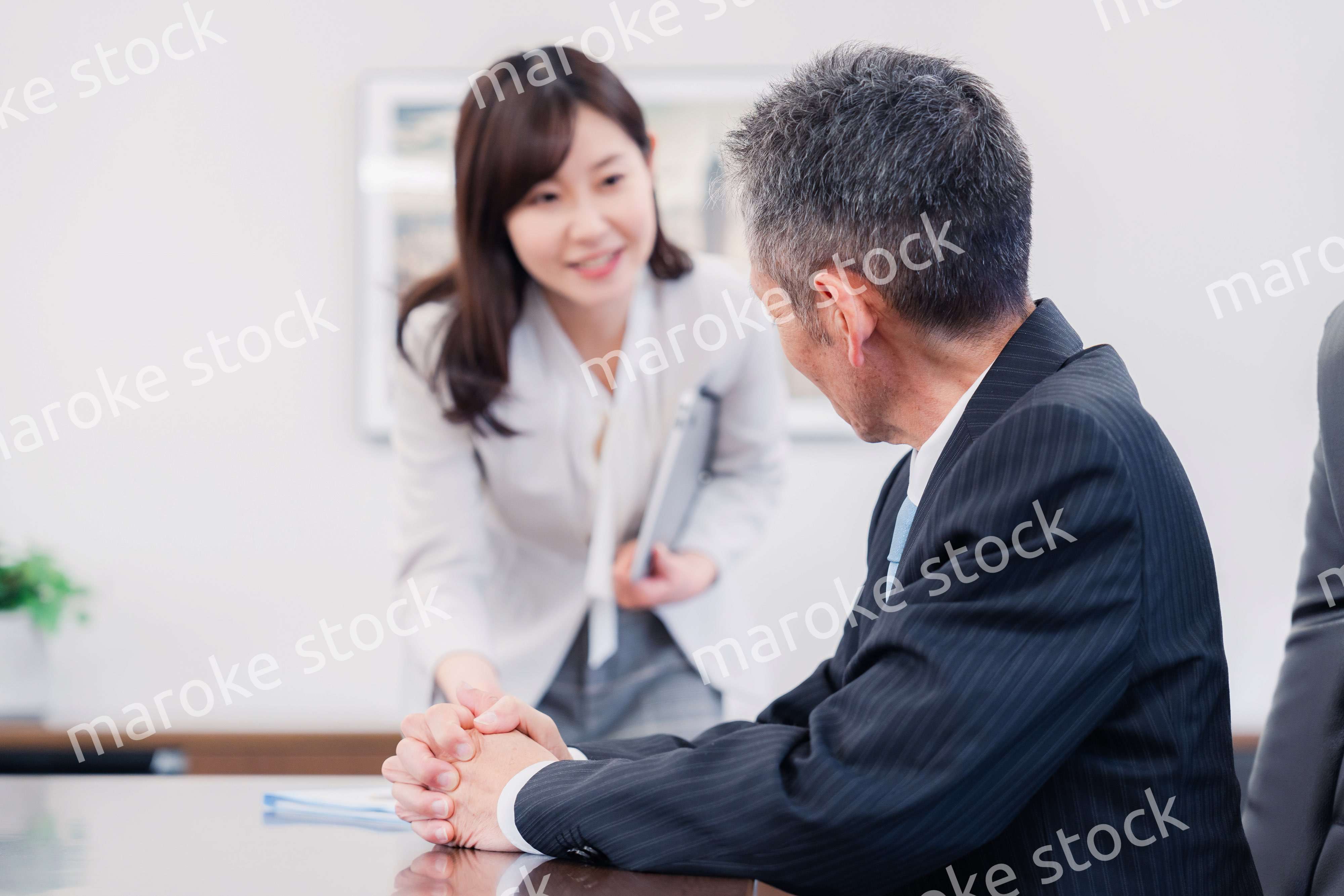 役員に報告をする秘書の女性