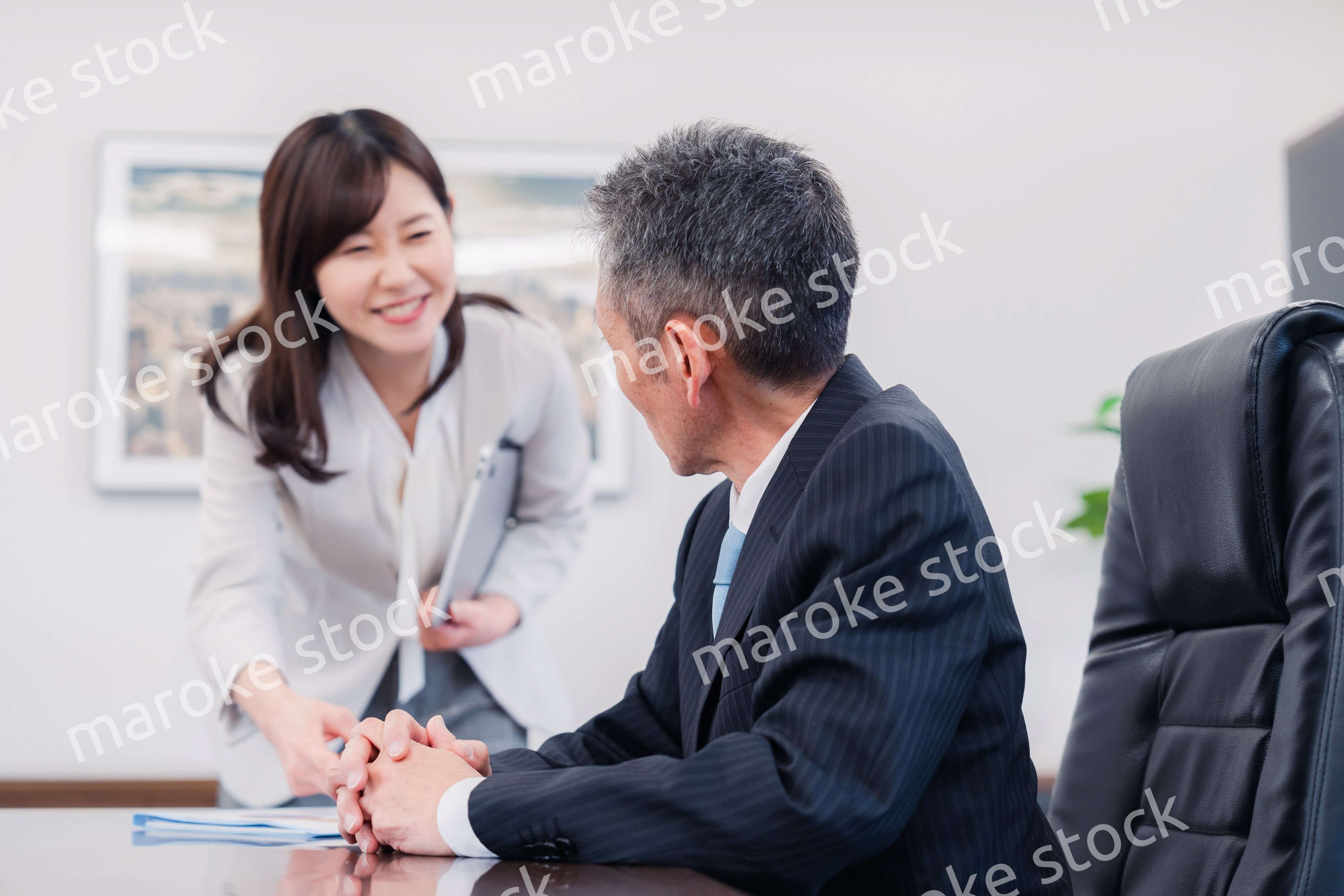 役員に報告をする秘書の女性