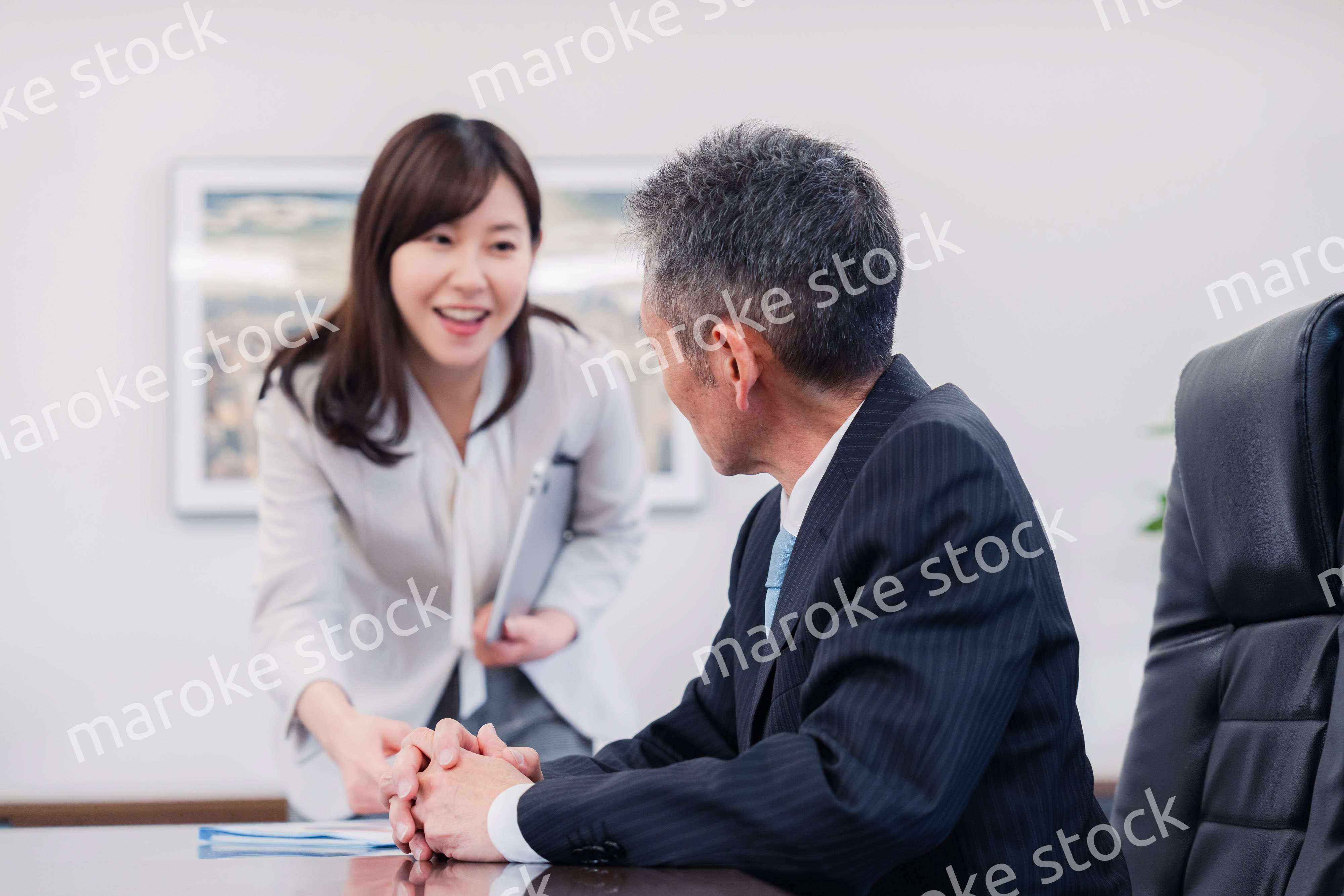 役員に報告をする秘書の女性