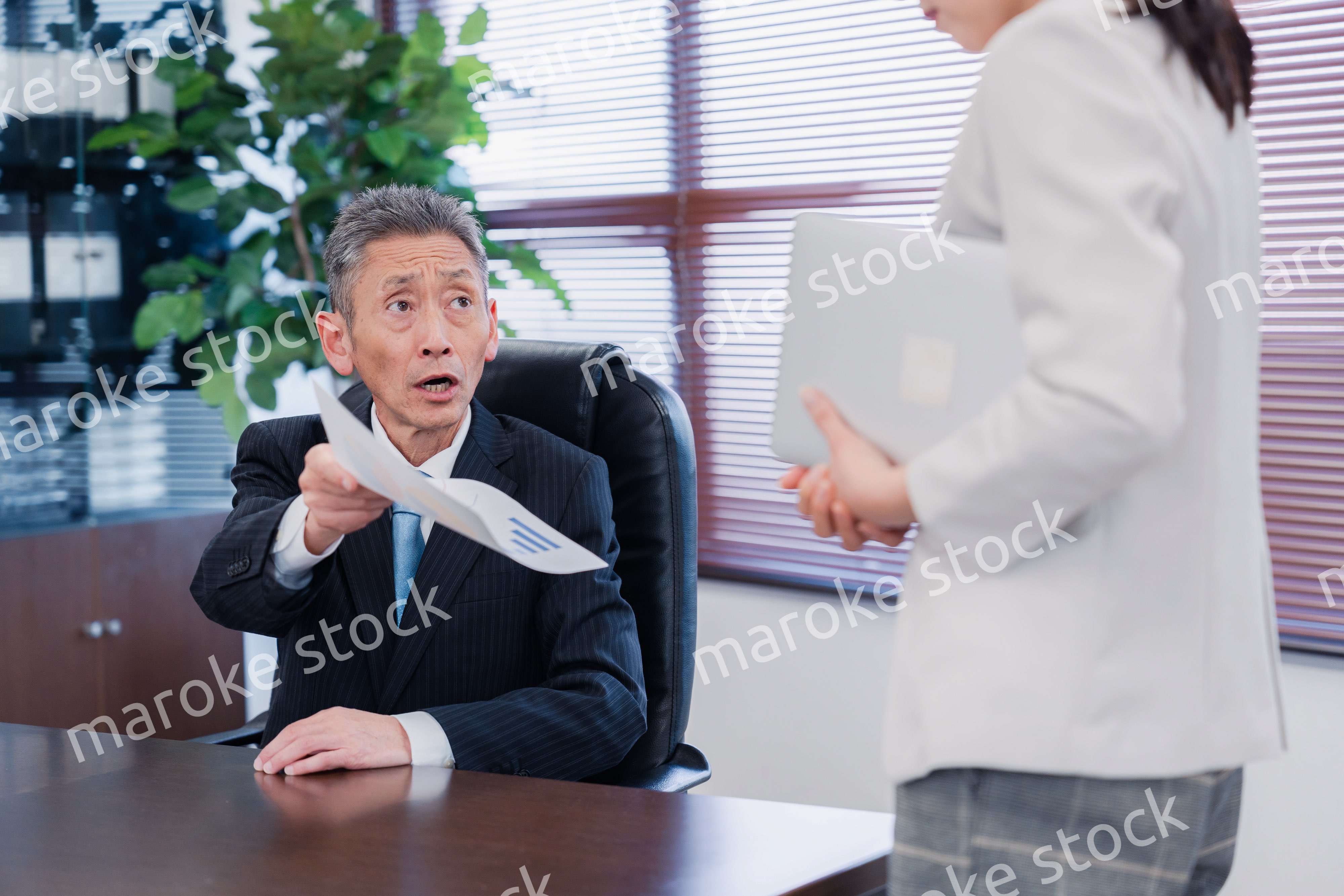 書類を突き返す会社役員の男性
