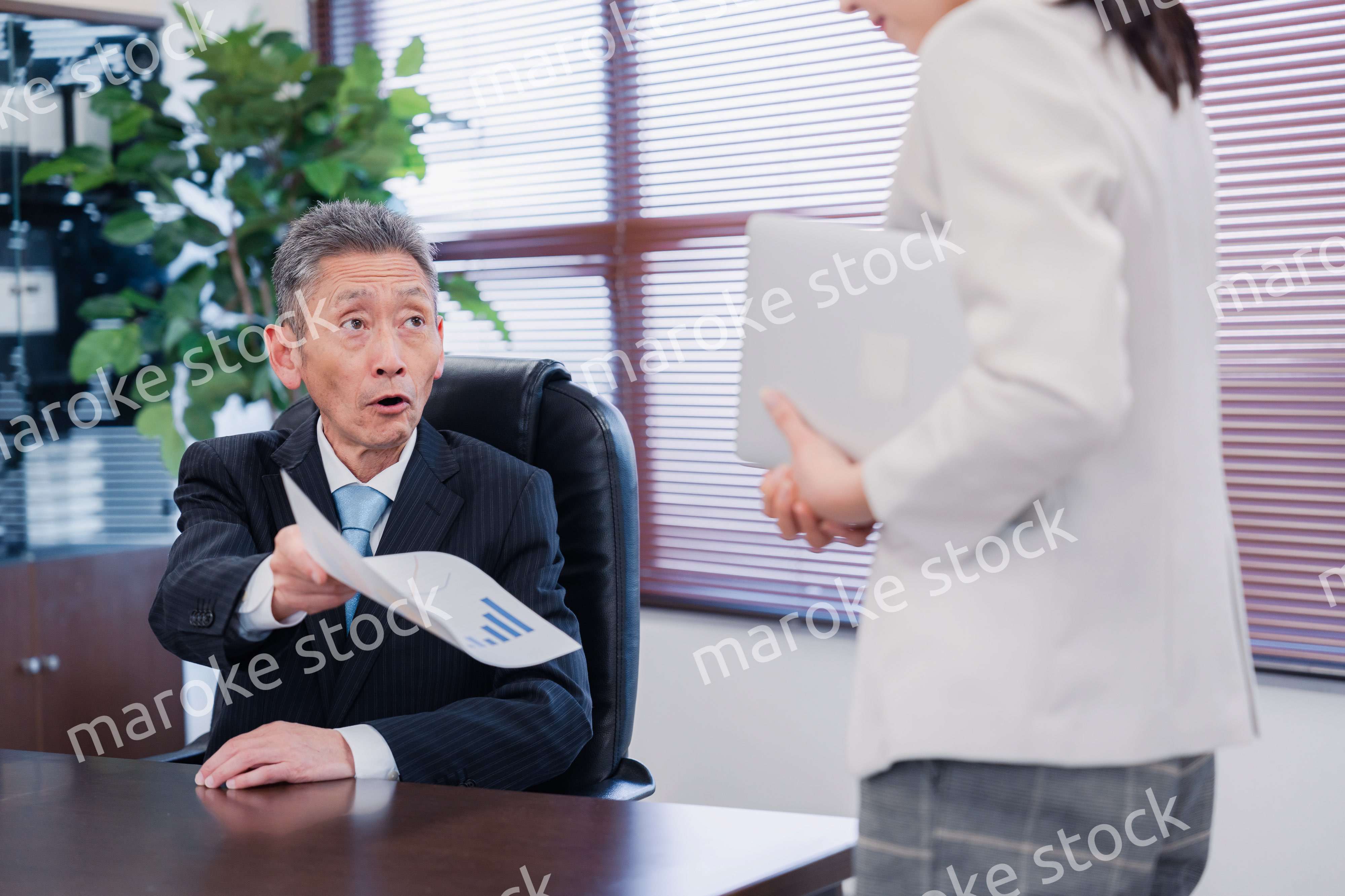 書類を突き返す会社役員の男性