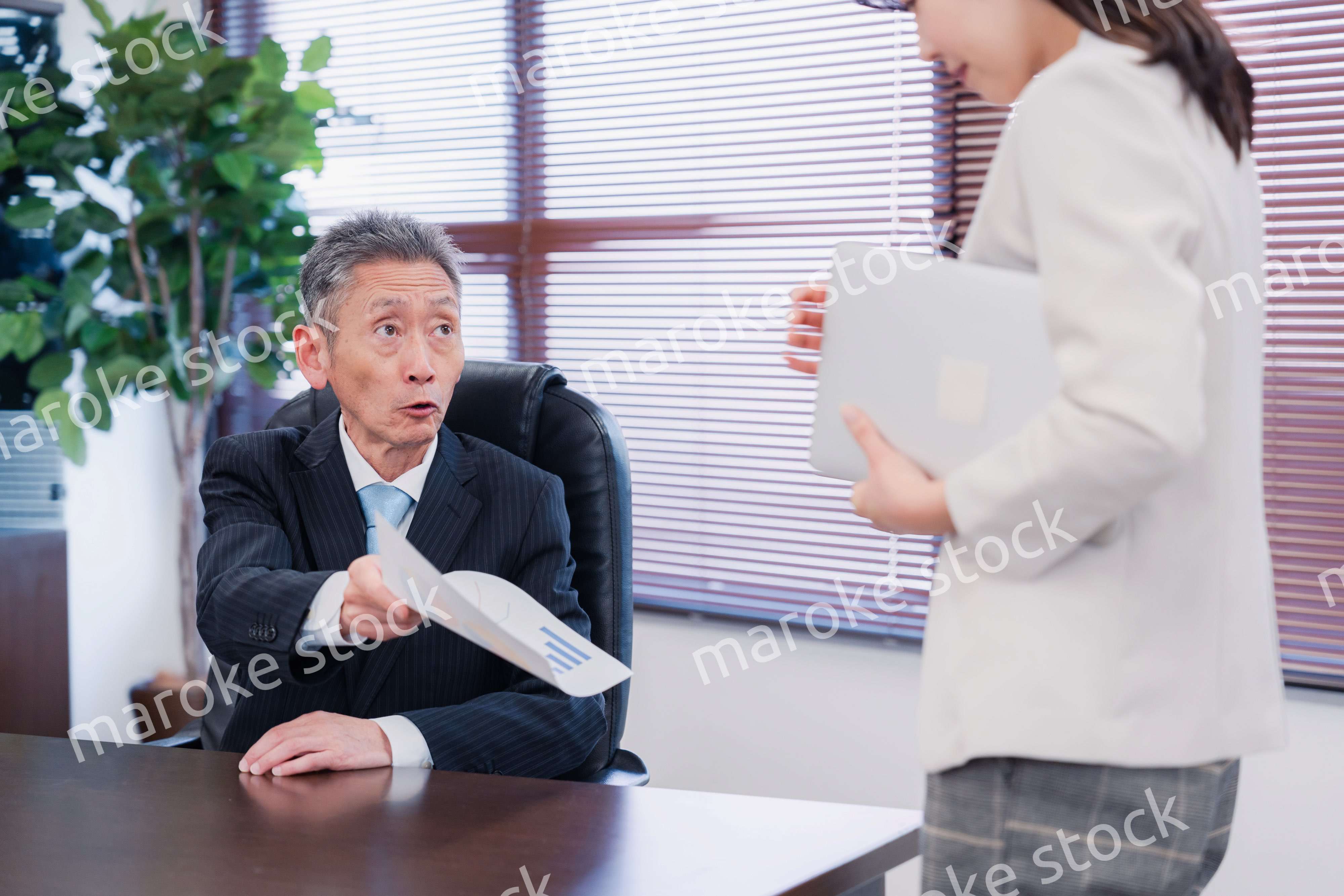 書類を突き返す会社役員の男性