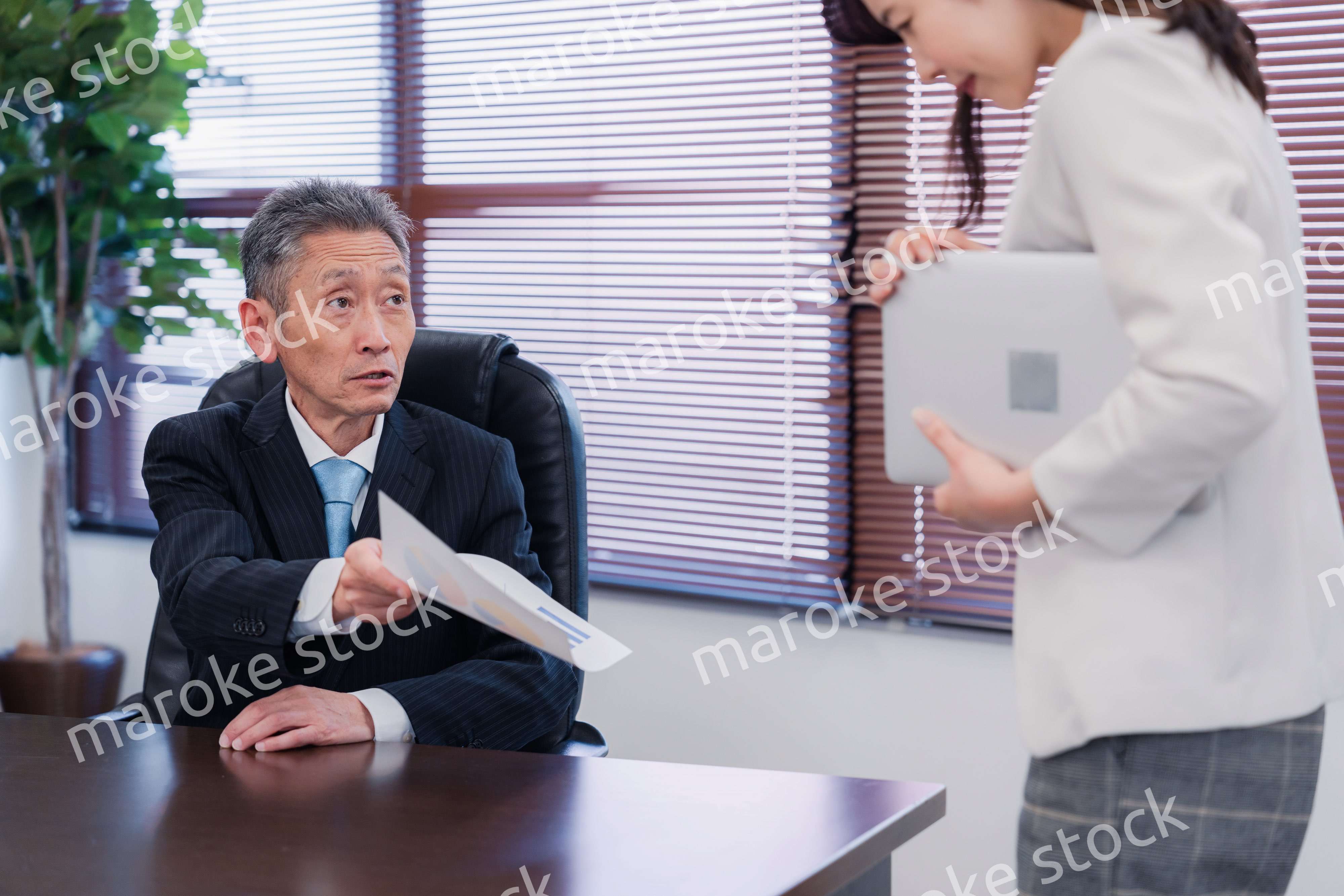 書類を突き返す会社役員の男性