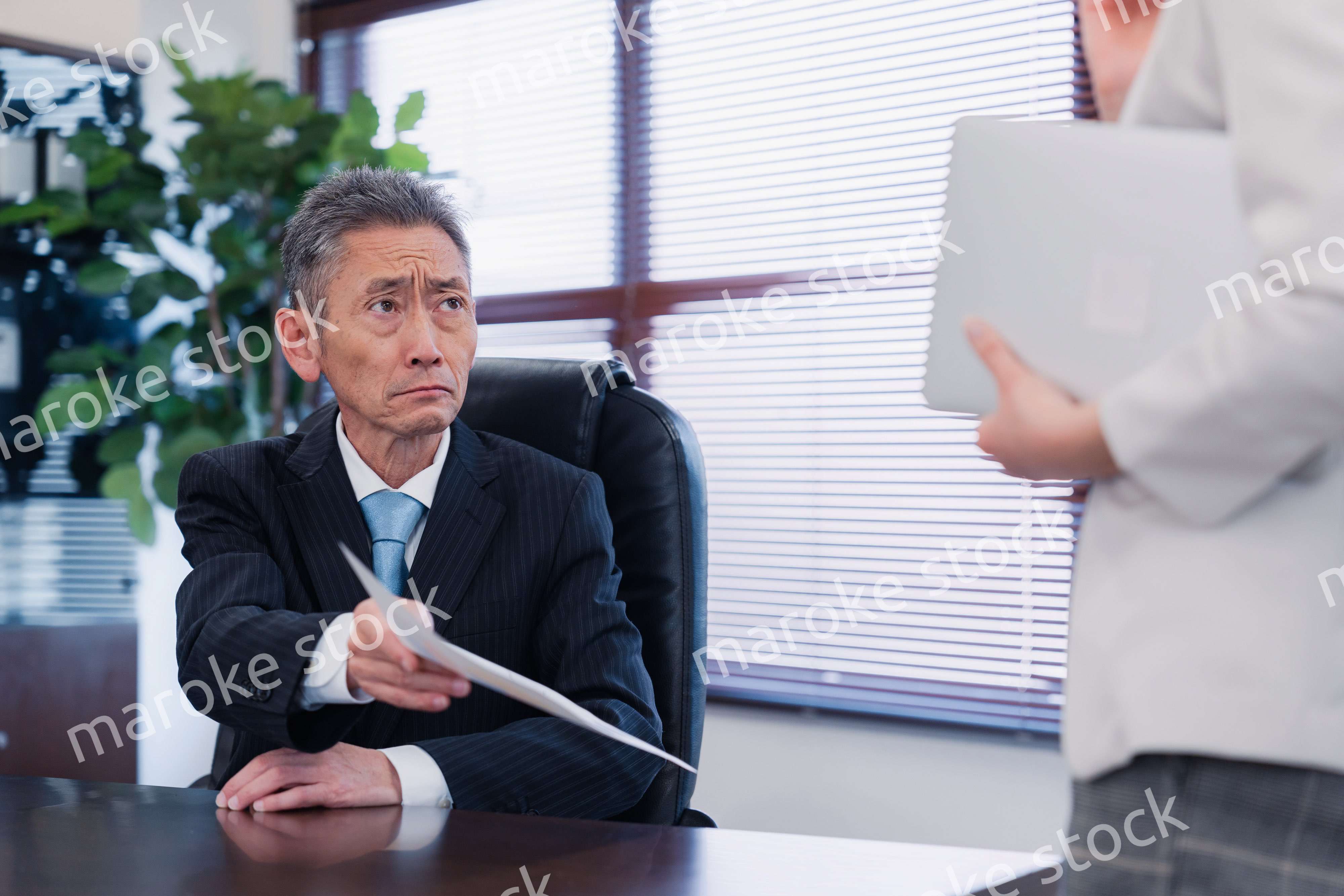 書類を突き返す会社役員の男性