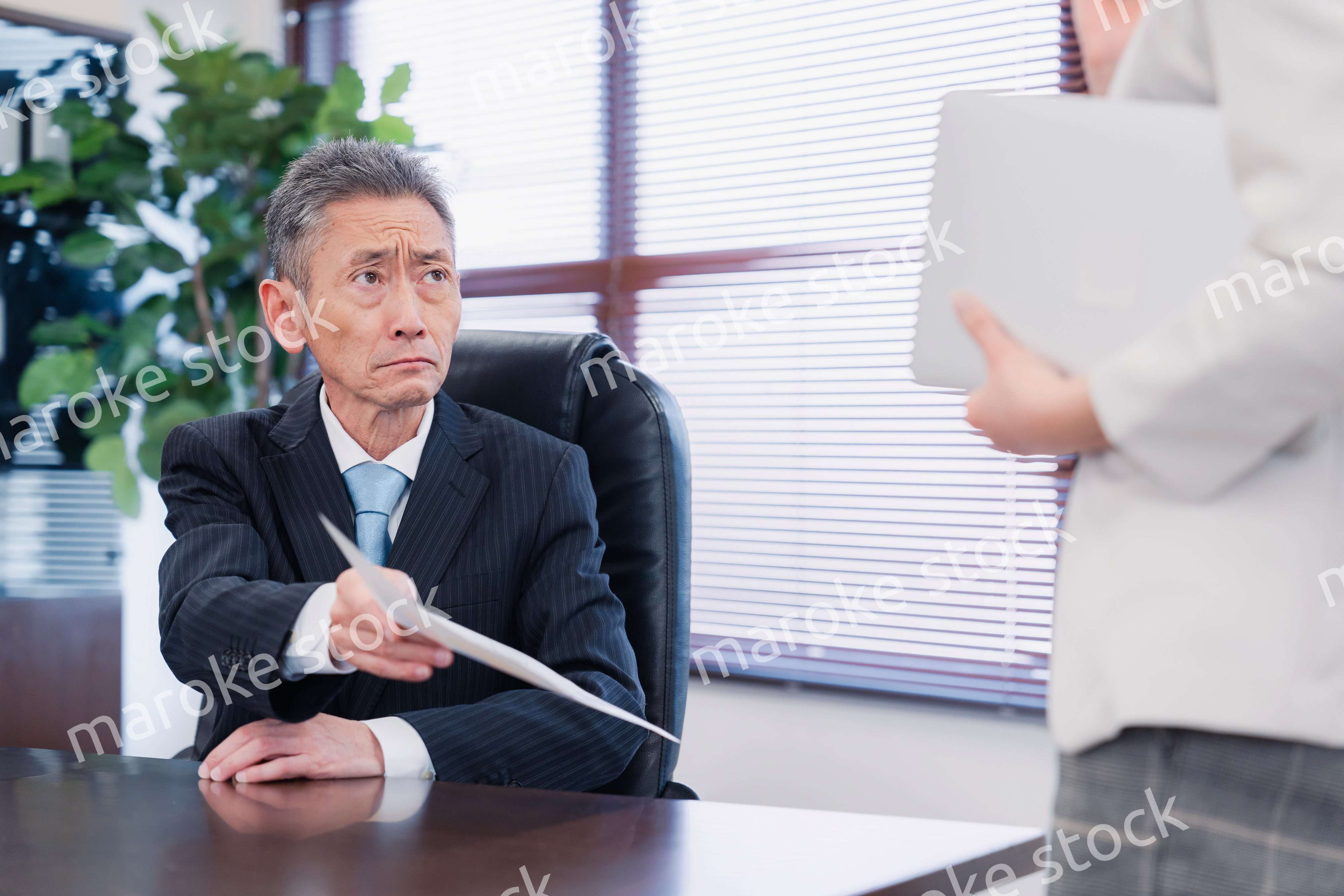 書類を突き返す会社役員の男性