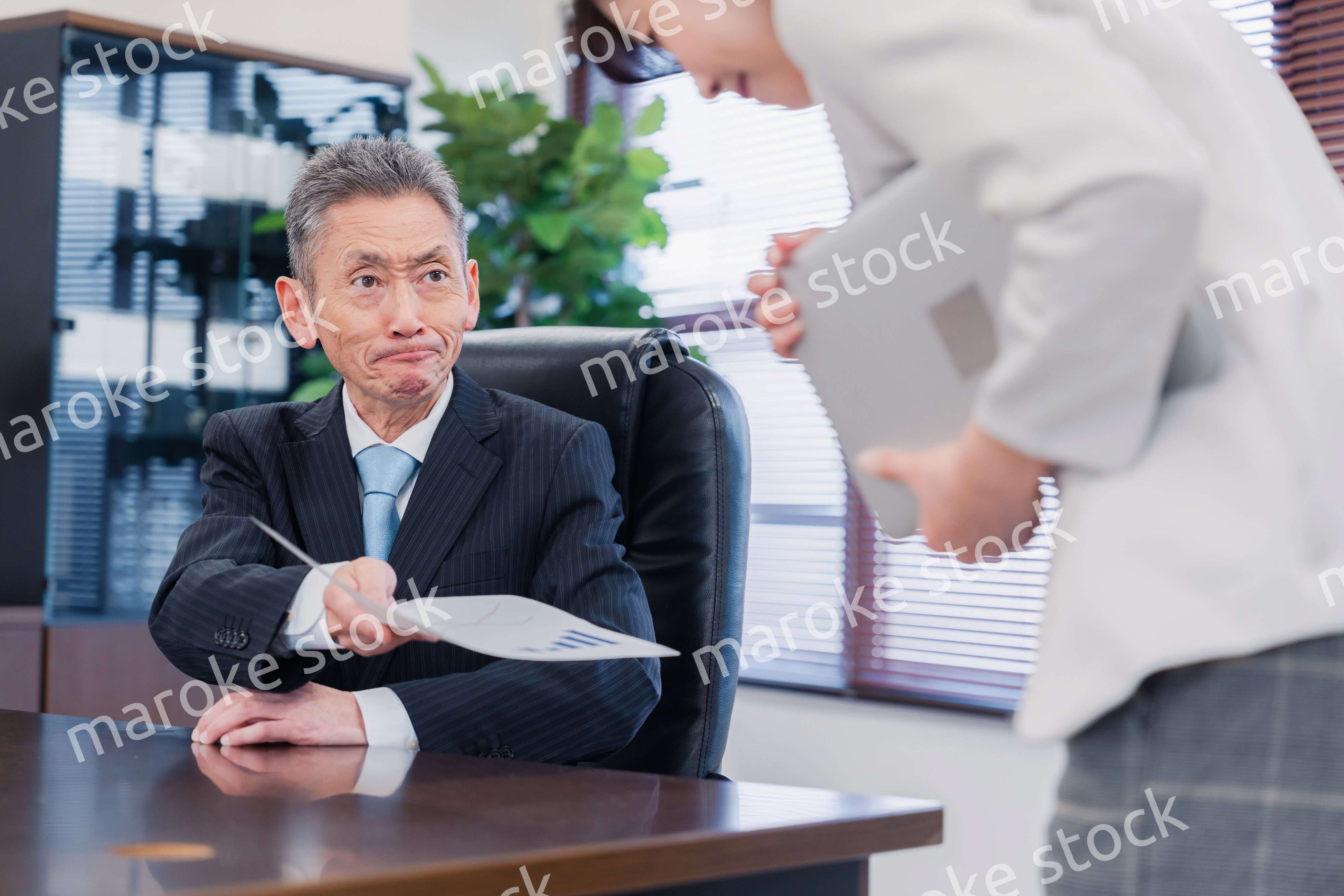 書類を突き返す会社役員の男性