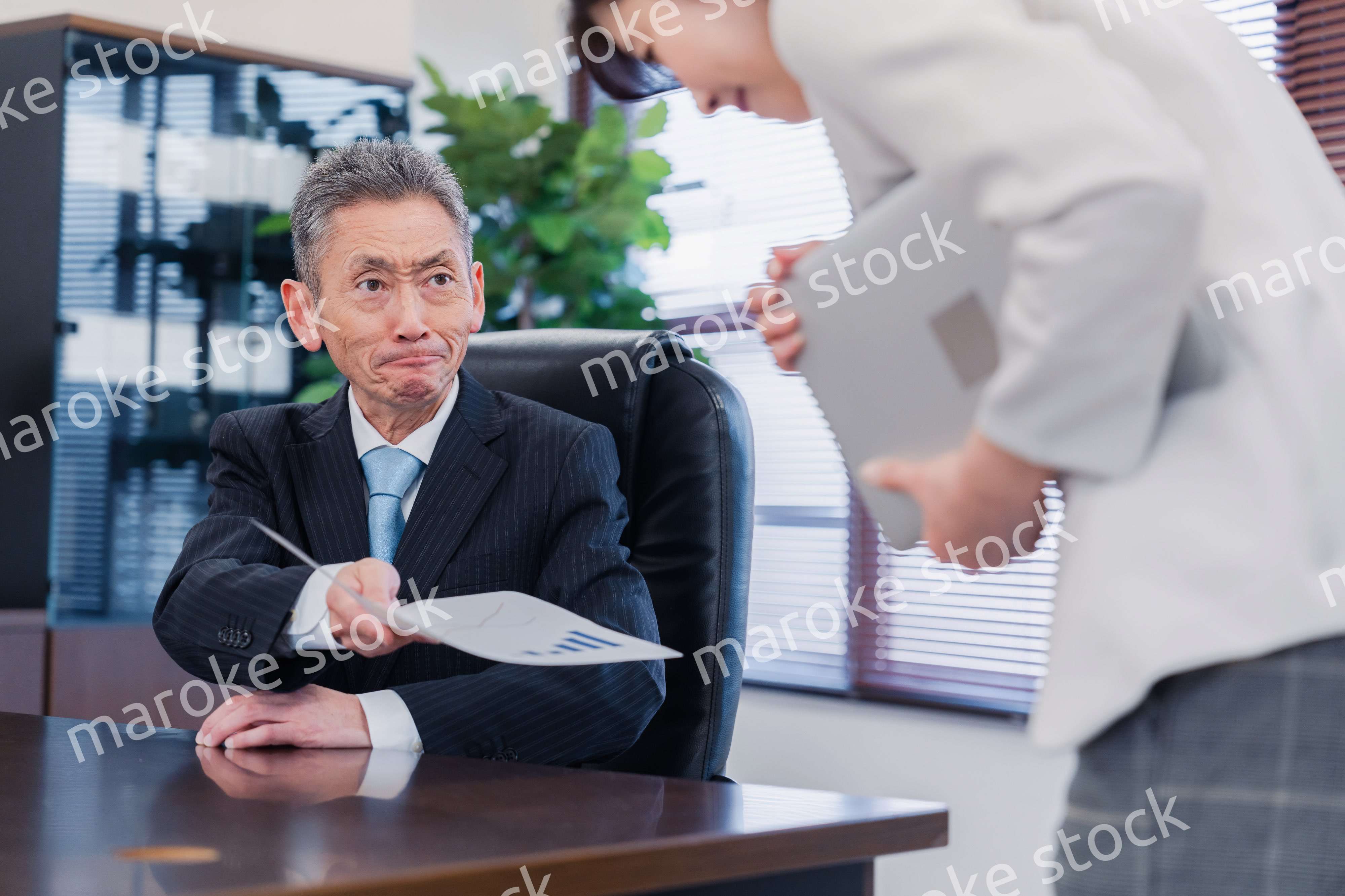 書類を突き返す会社役員の男性