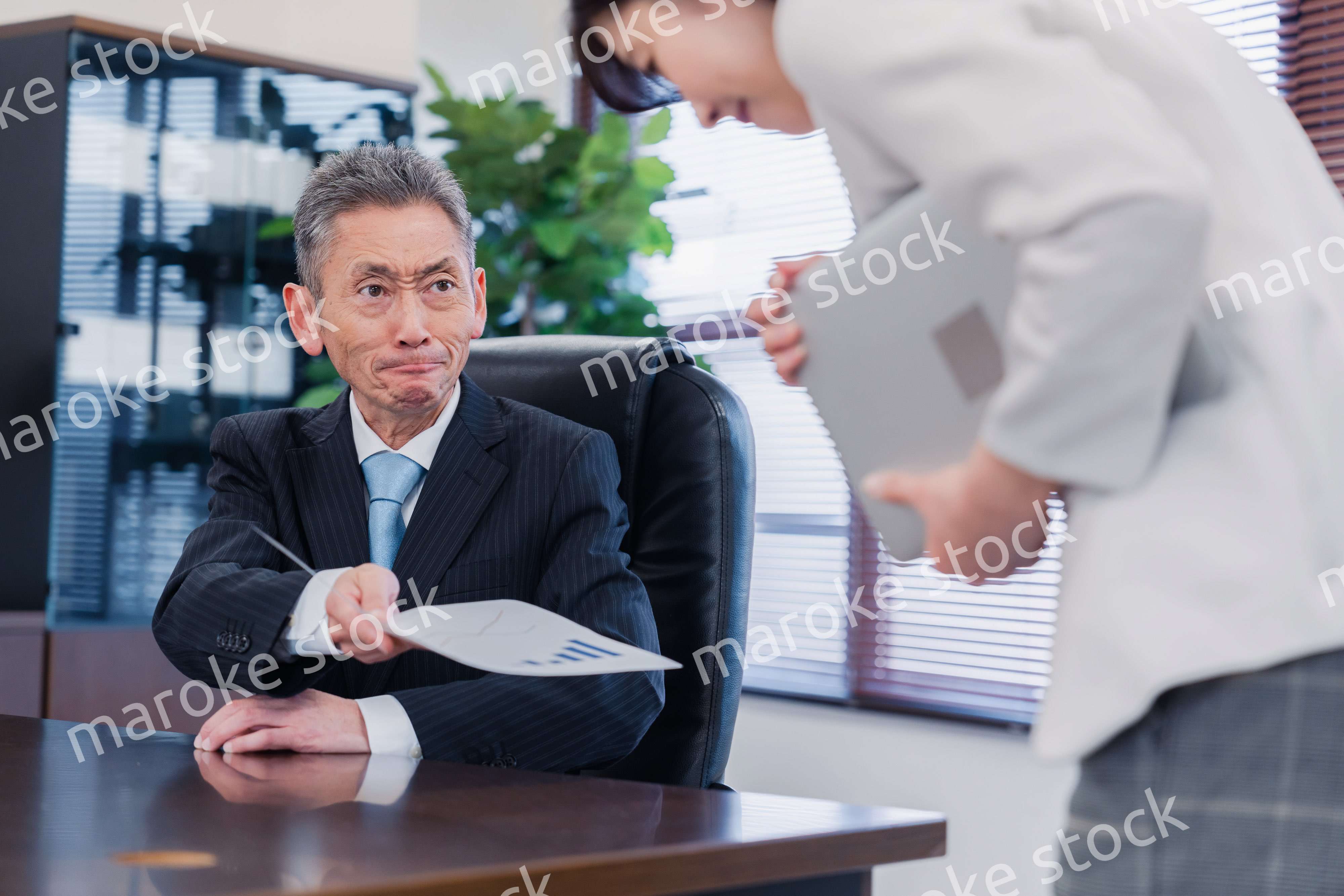 書類を突き返す会社役員の男性