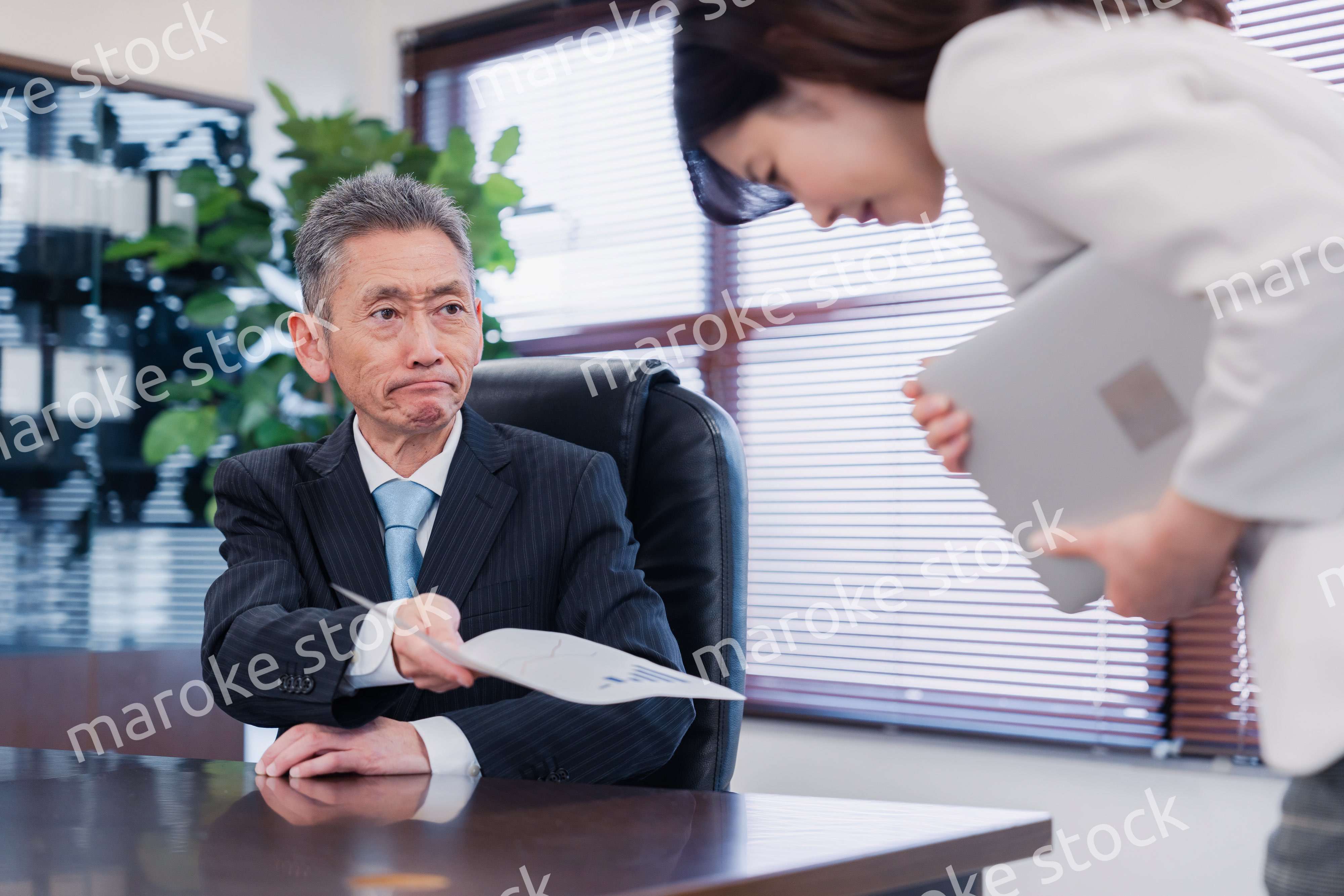 書類を突き返す会社役員の男性