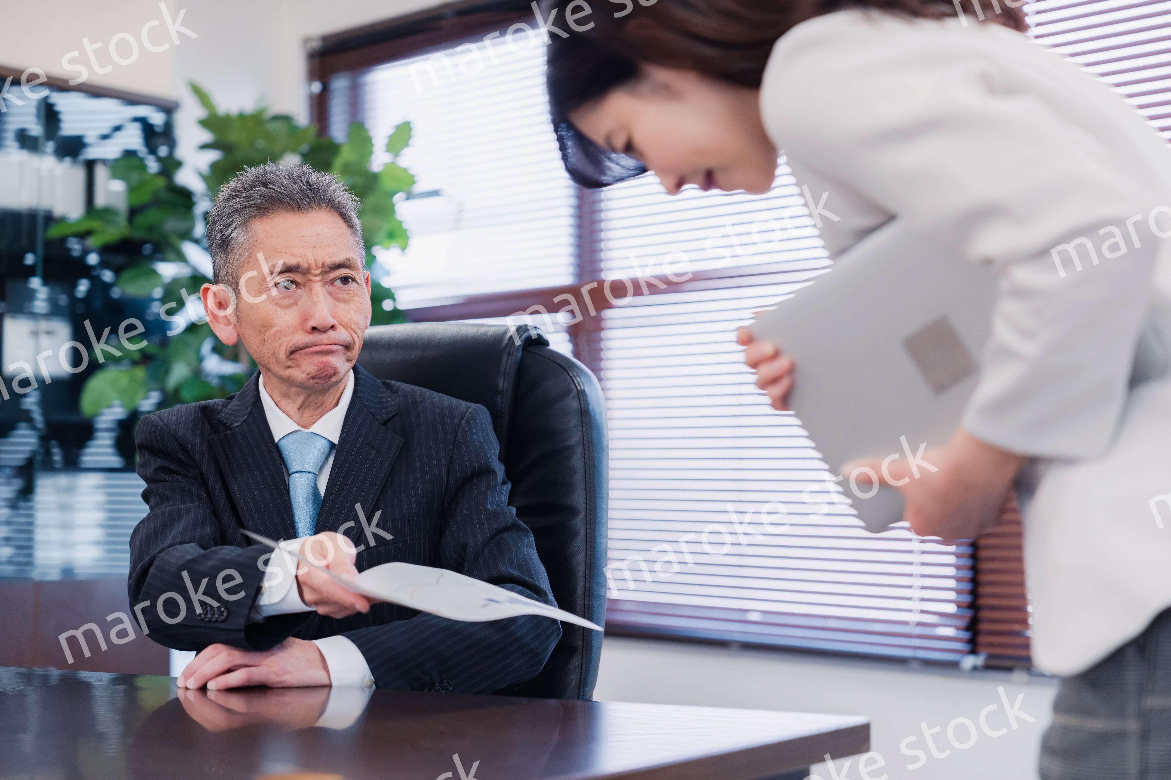 書類を突き返す会社役員の男性