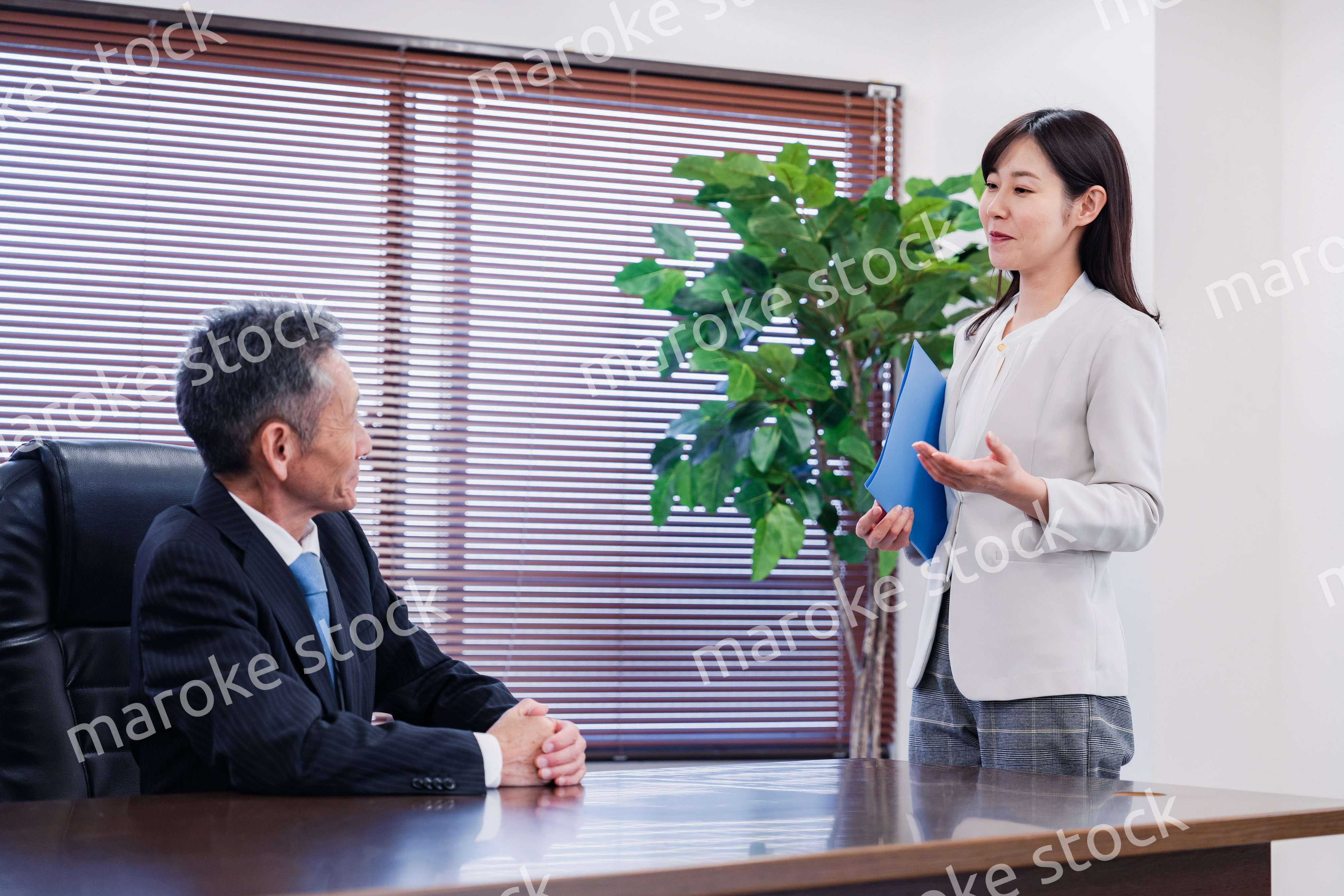 女性秘書と笑顔で話す男性