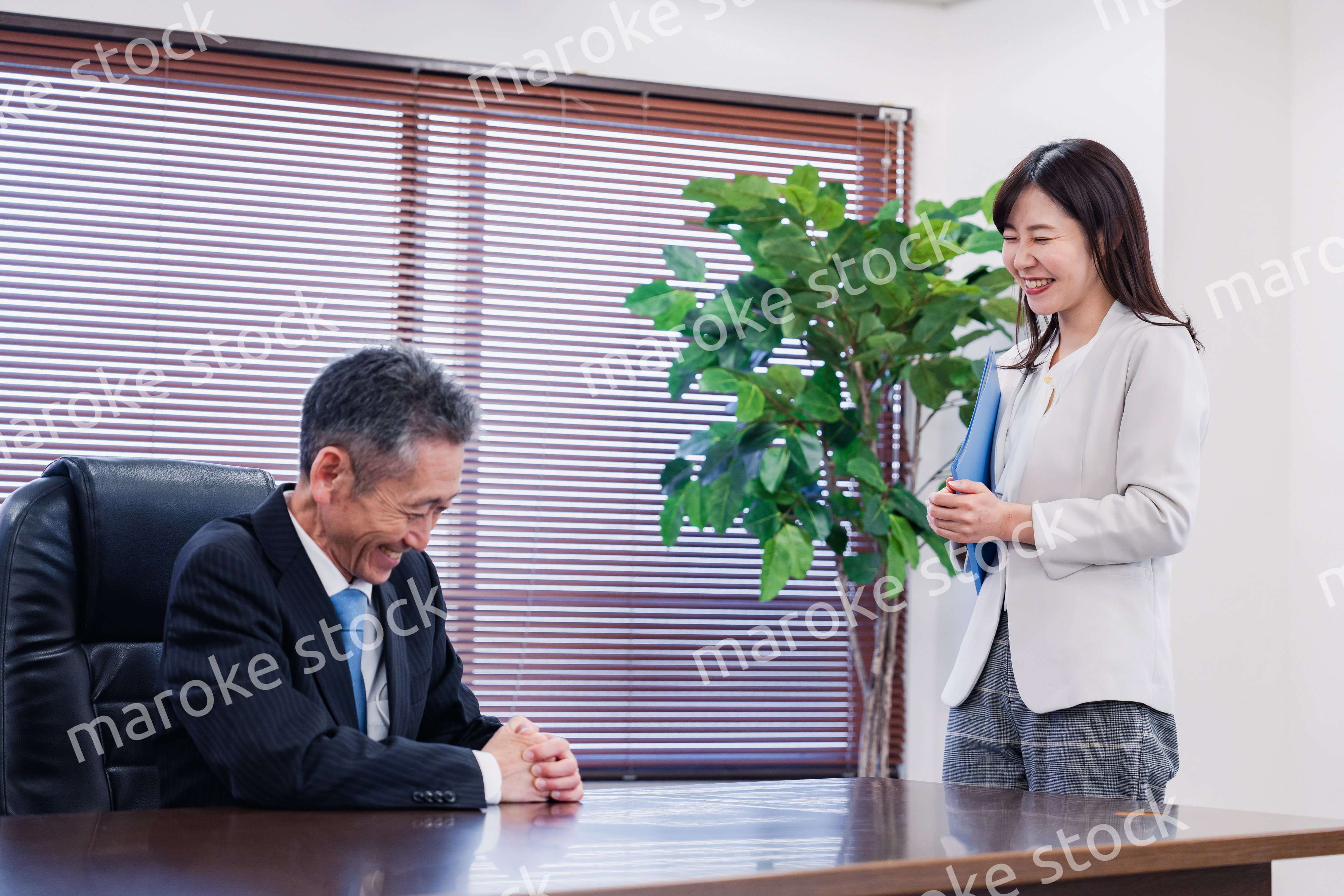 女性秘書と笑顔で話す男性