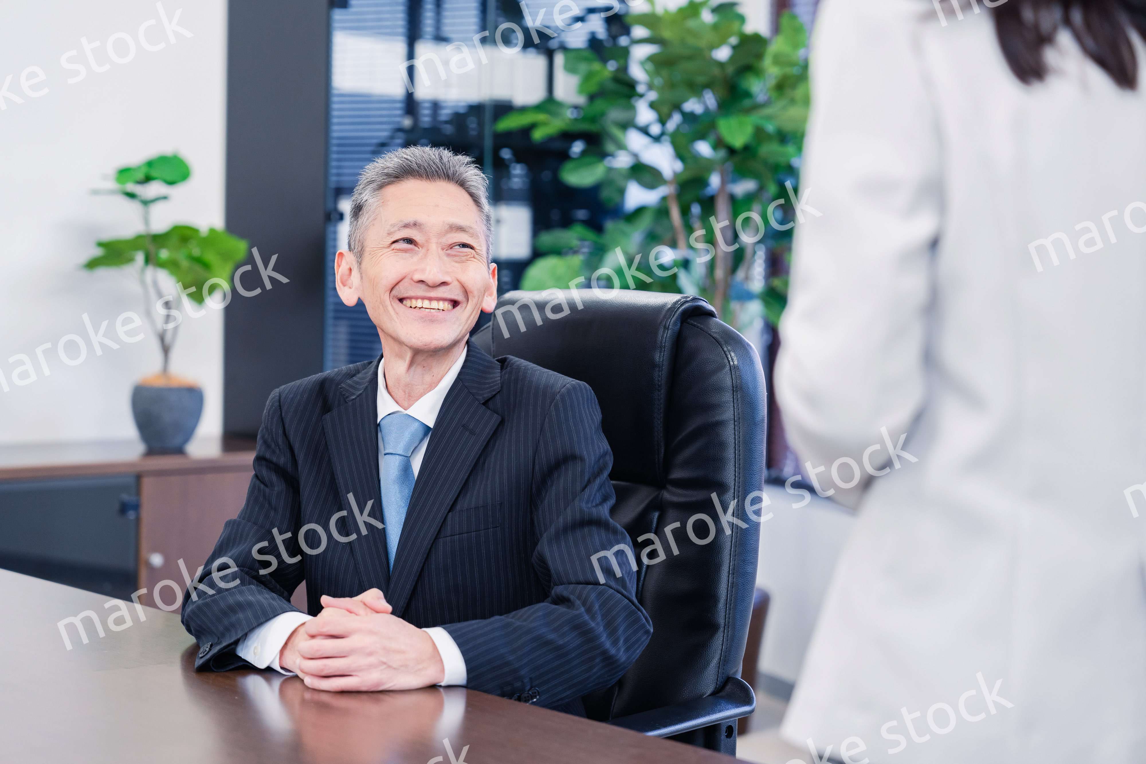 女性秘書と笑顔で話す男性