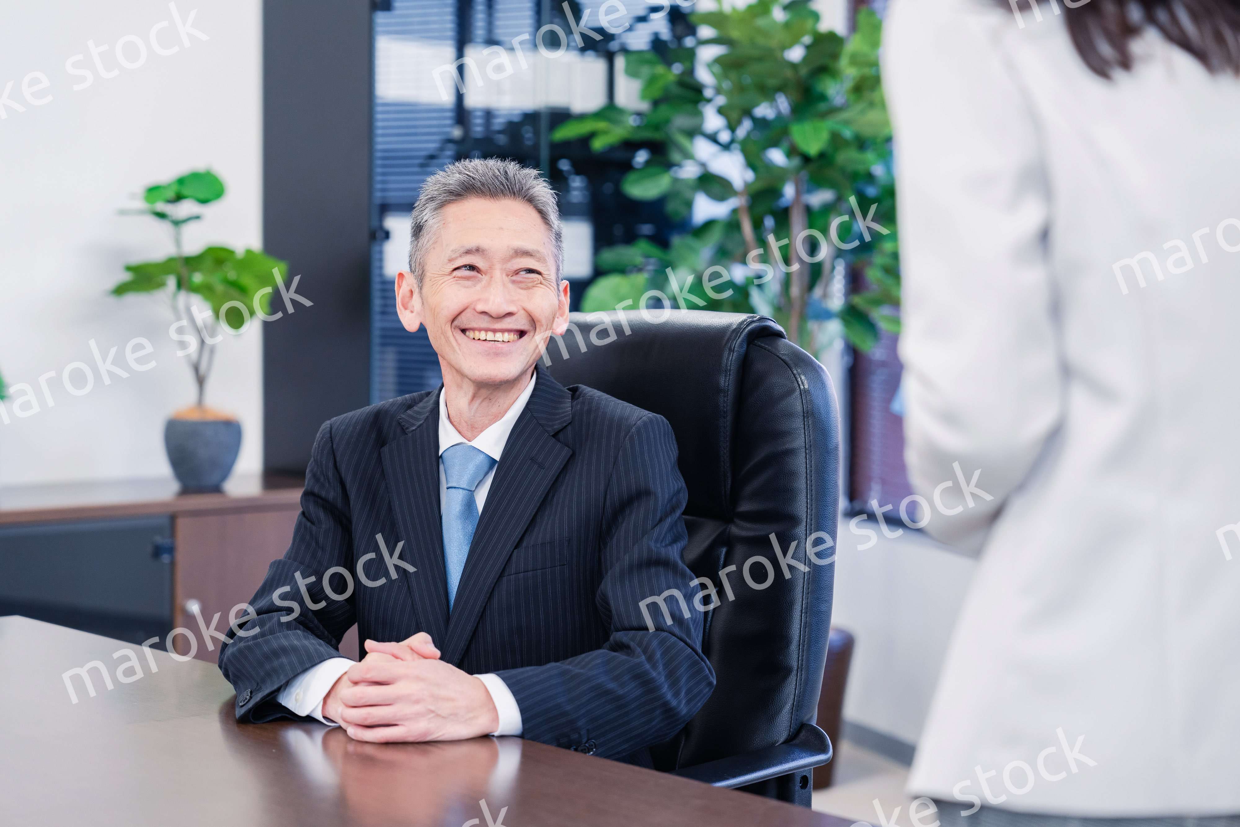 女性秘書と笑顔で話す男性