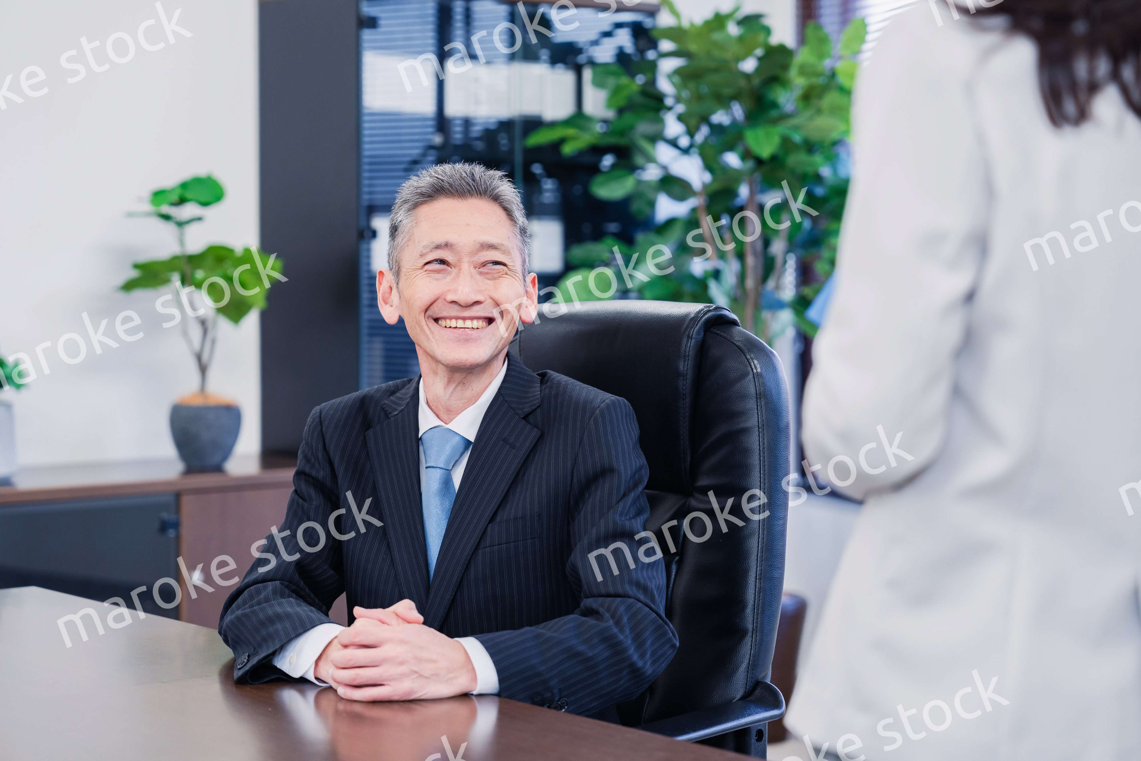 女性秘書と笑顔で話す男性