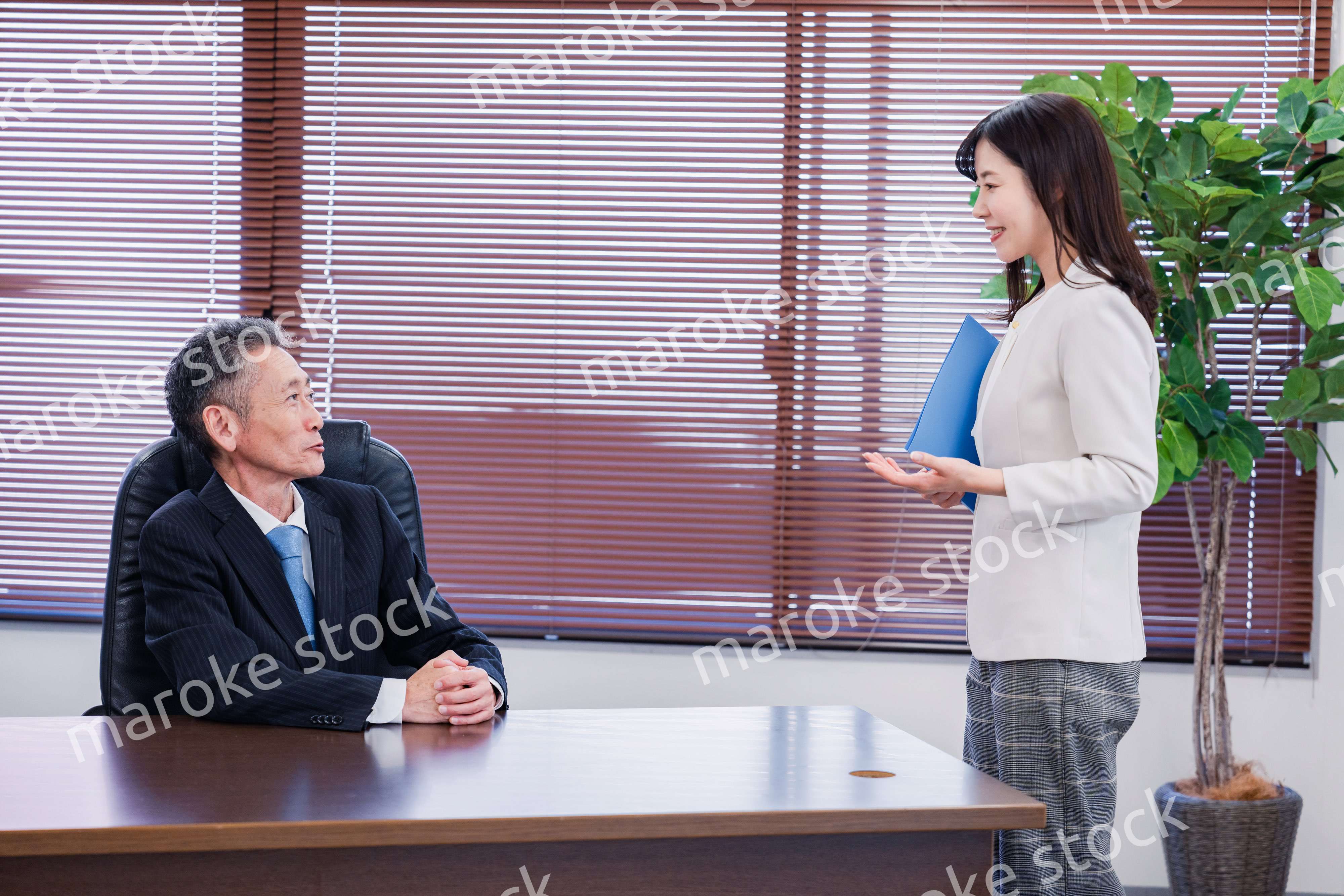 女性秘書と笑顔で話す男性