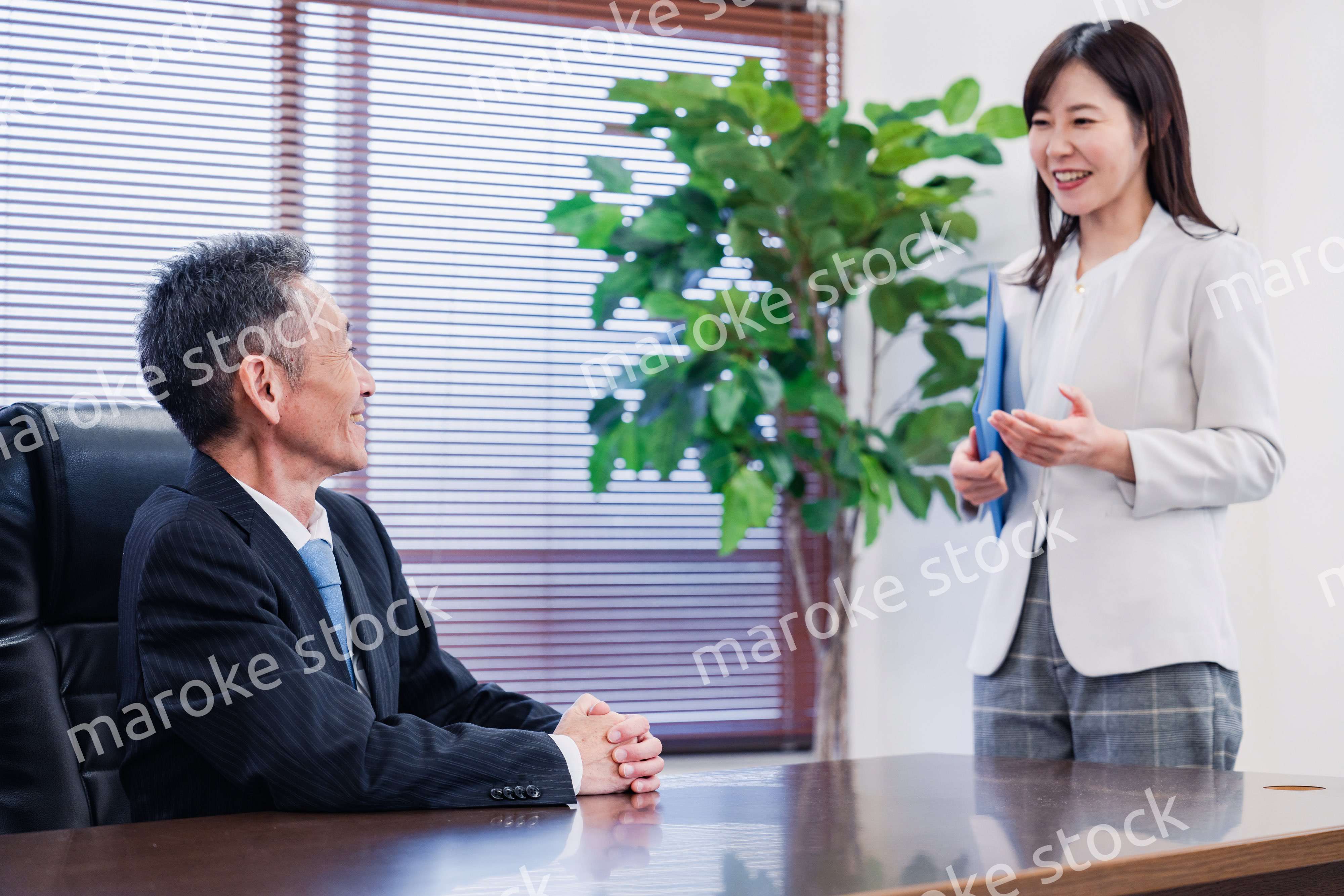 女性秘書と笑顔で話す男性