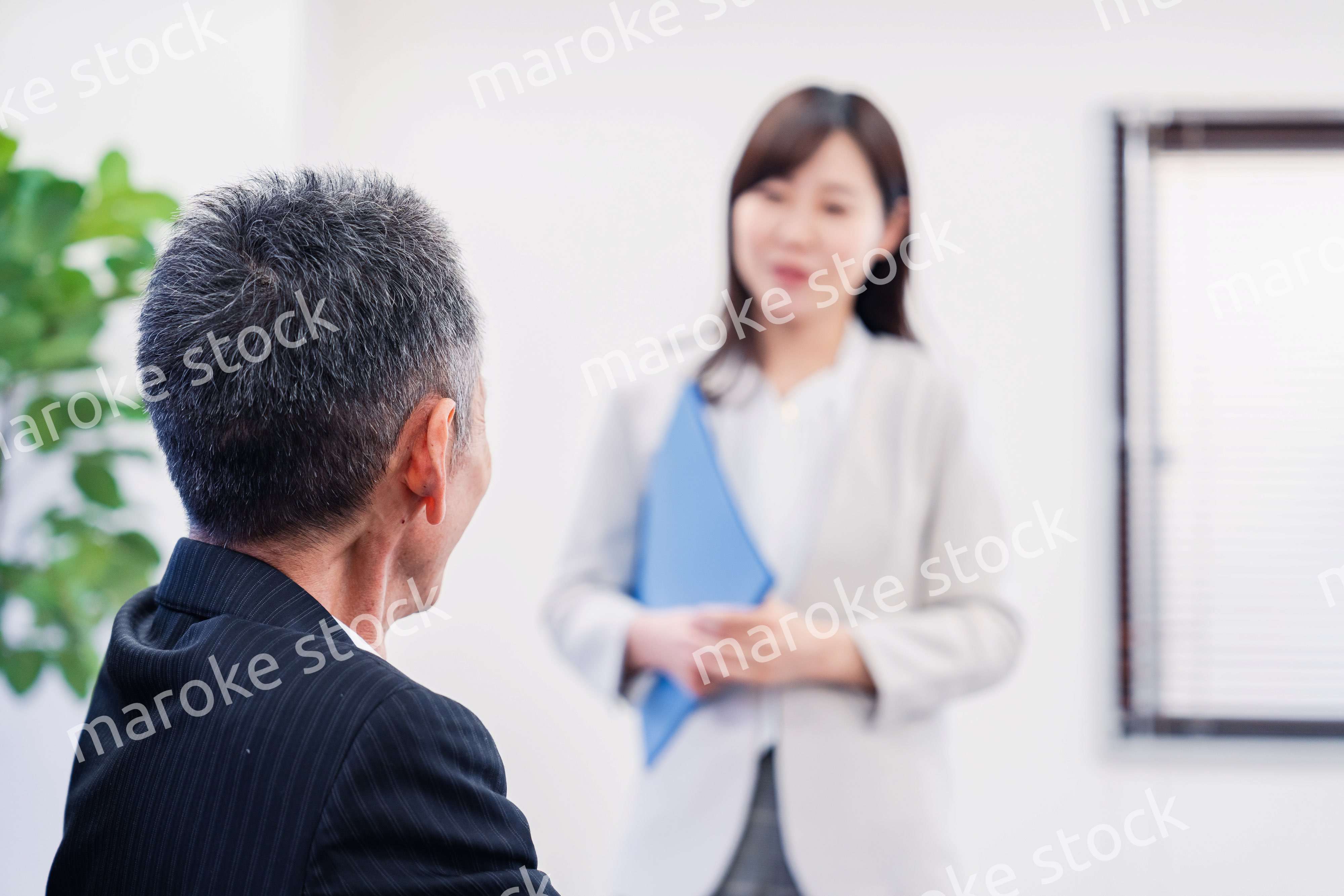 女性秘書と笑顔で話す男性