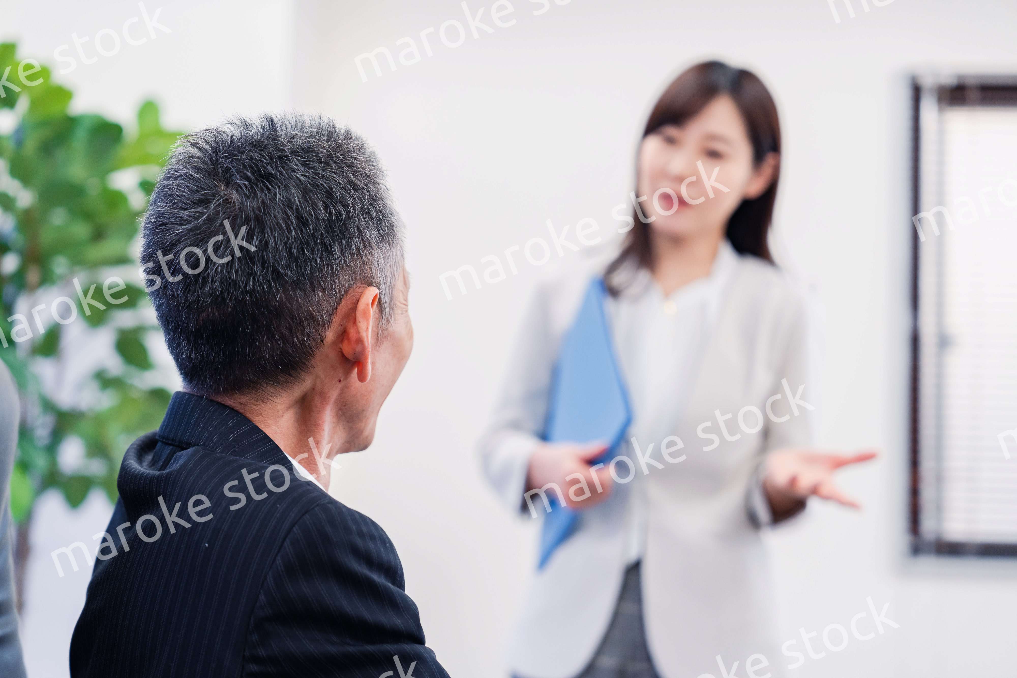 女性秘書と笑顔で話す男性