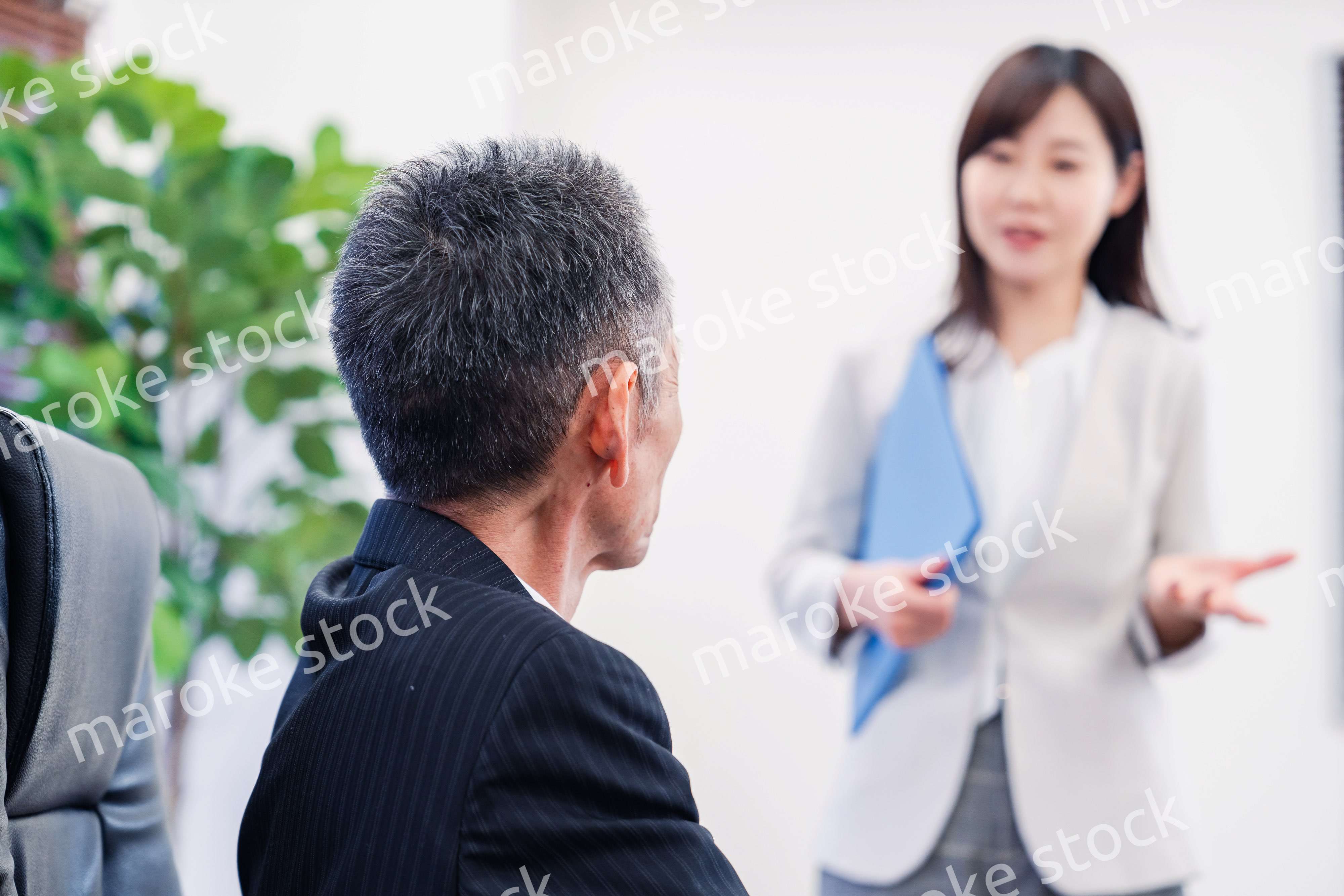 女性秘書と笑顔で話す男性