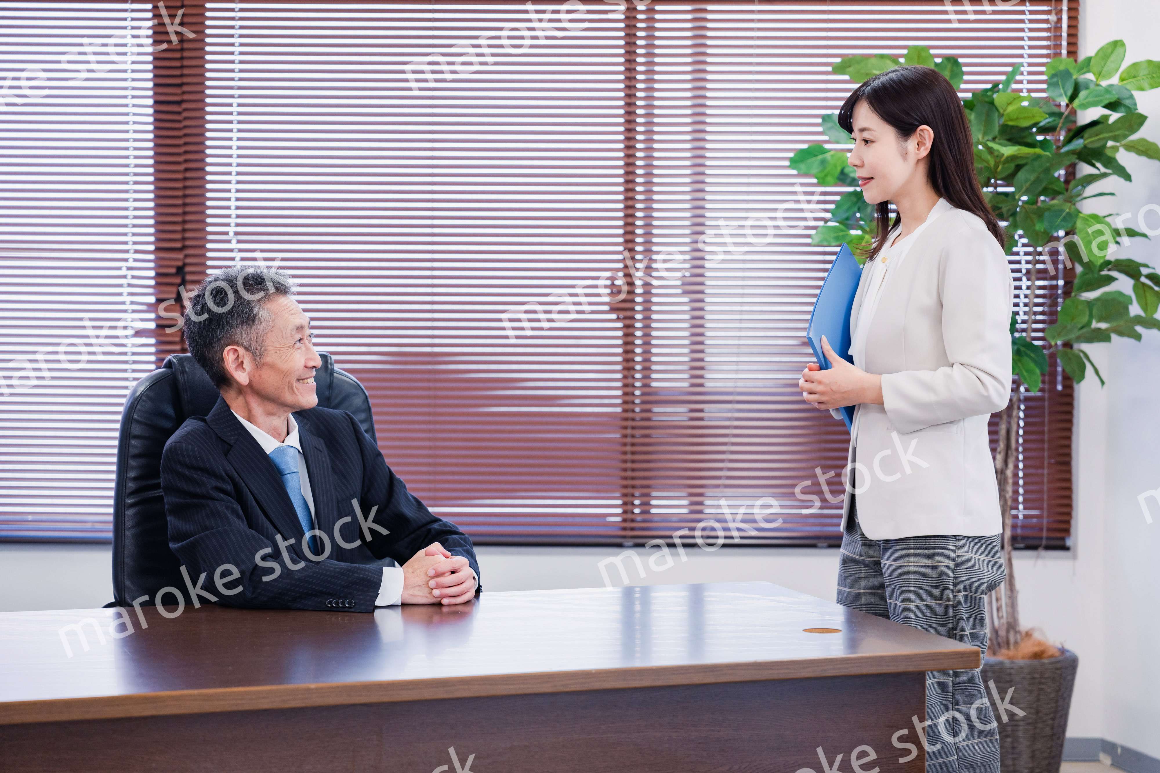 女性秘書と笑顔で話す男性