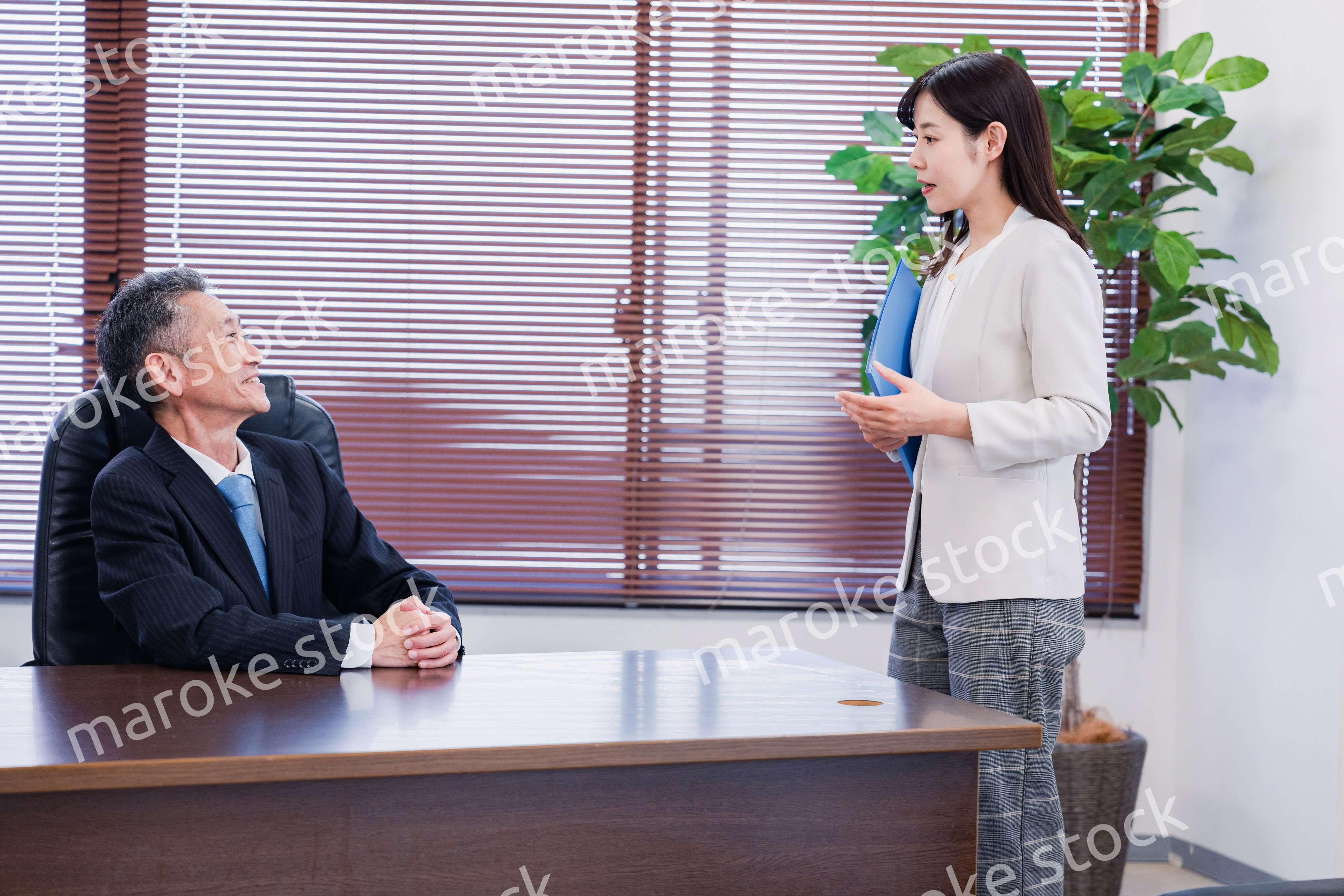 女性秘書と笑顔で話す男性