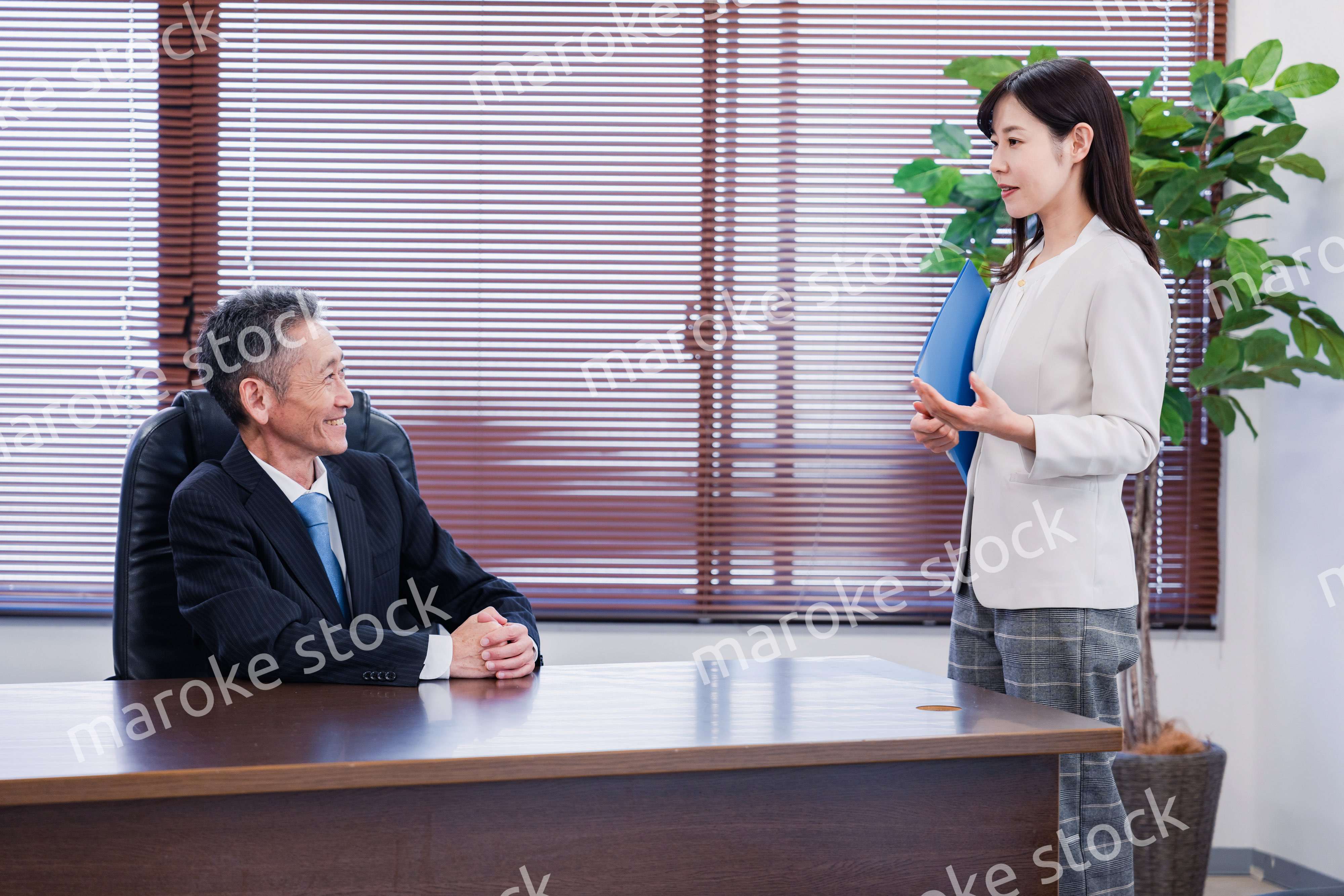 女性秘書と笑顔で話す男性