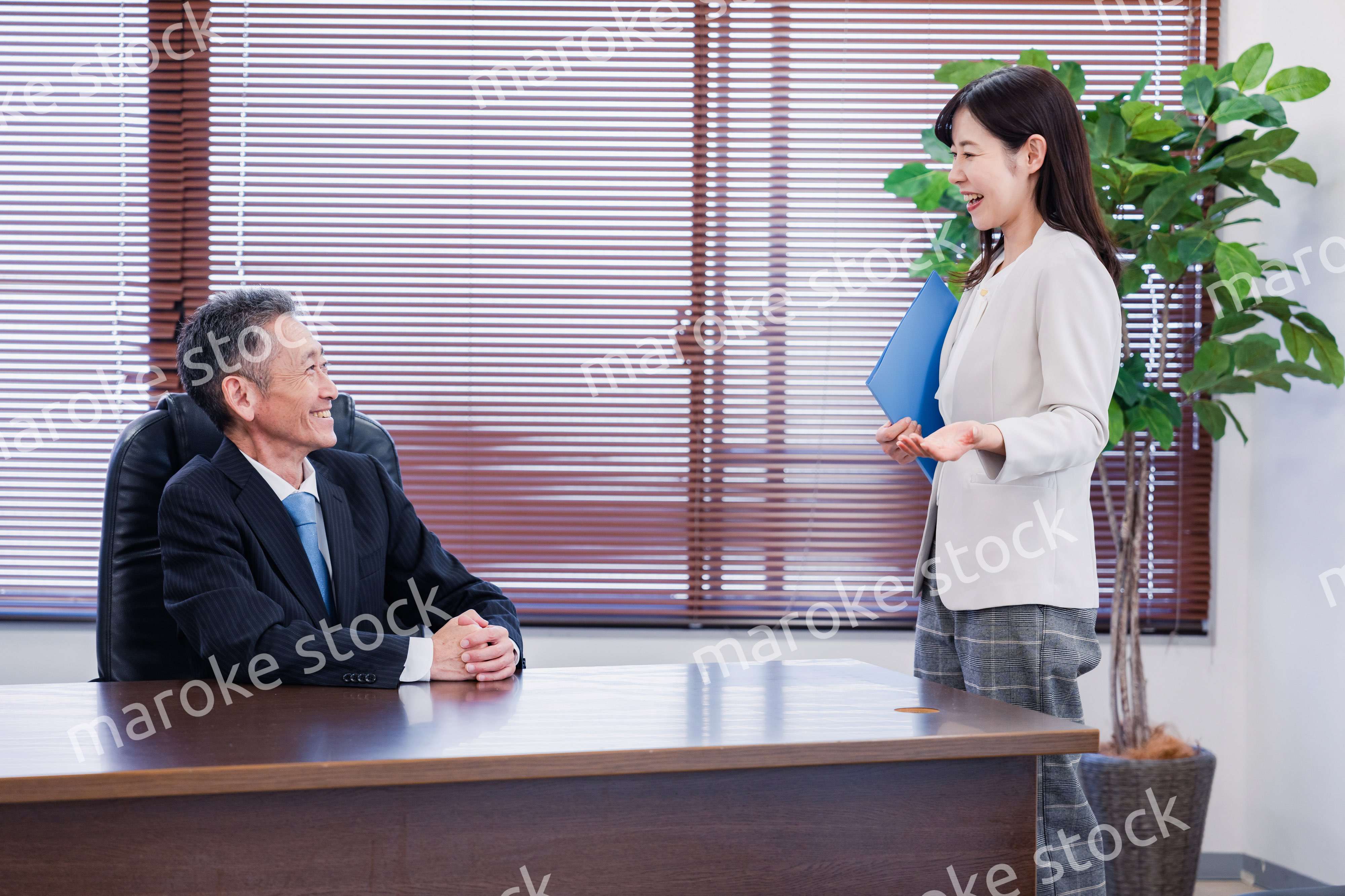 女性秘書と笑顔で話す男性