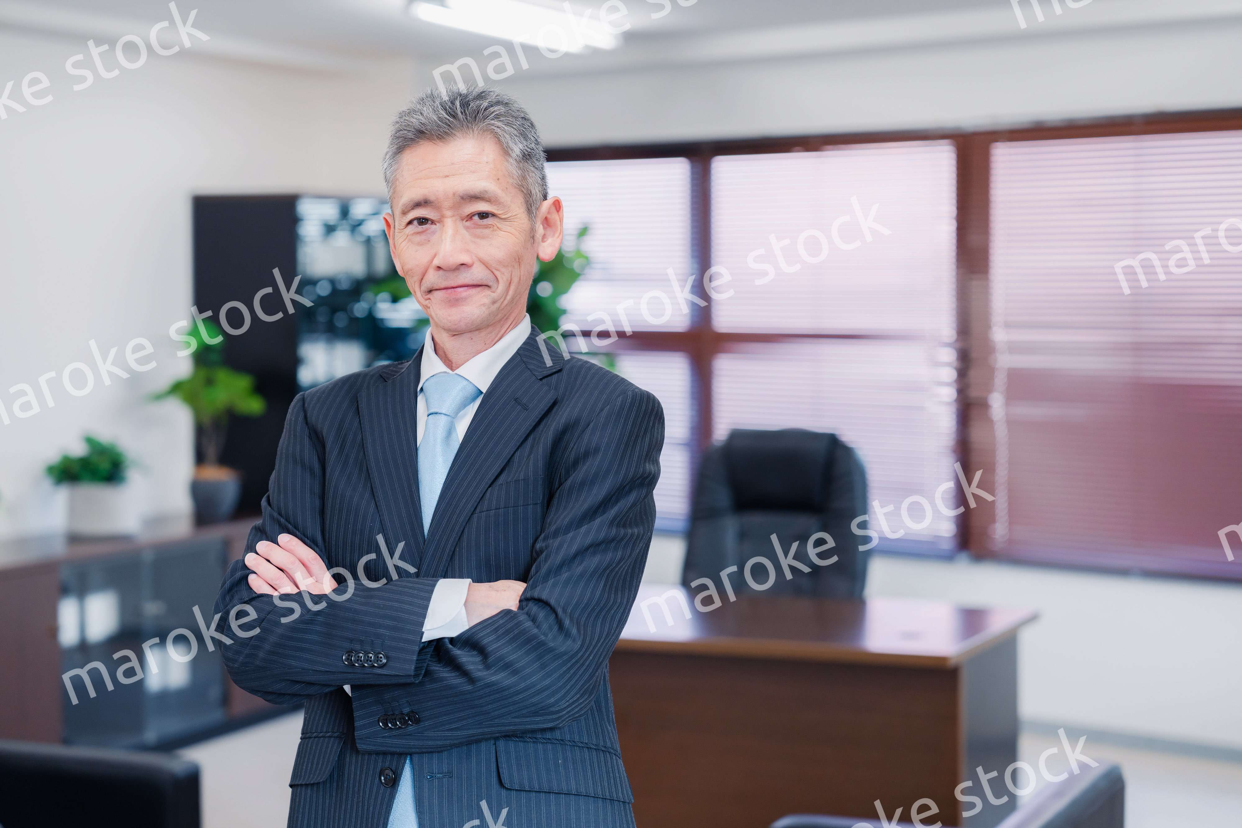 役員室で腕を組む経営者