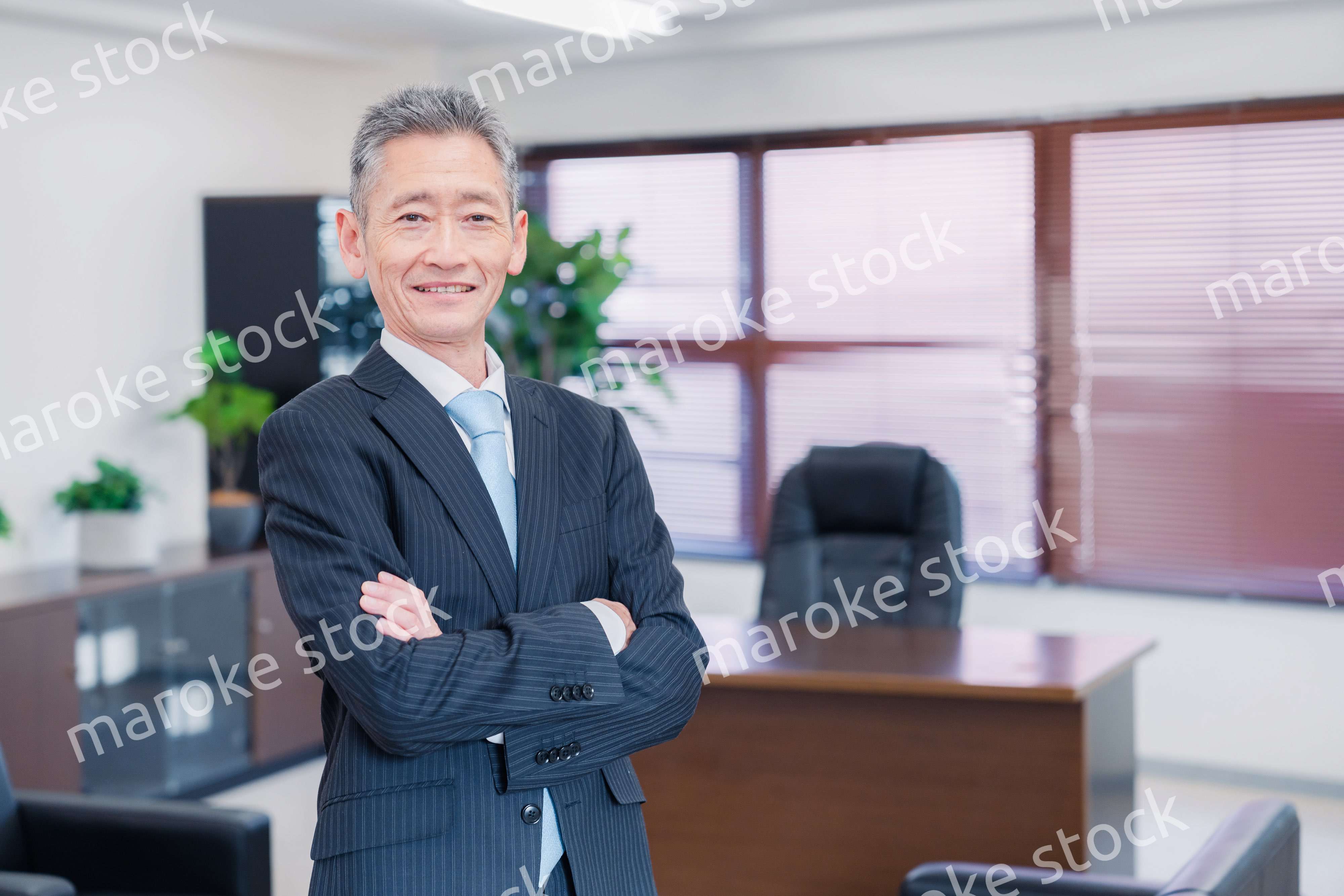 役員室で腕を組む経営者