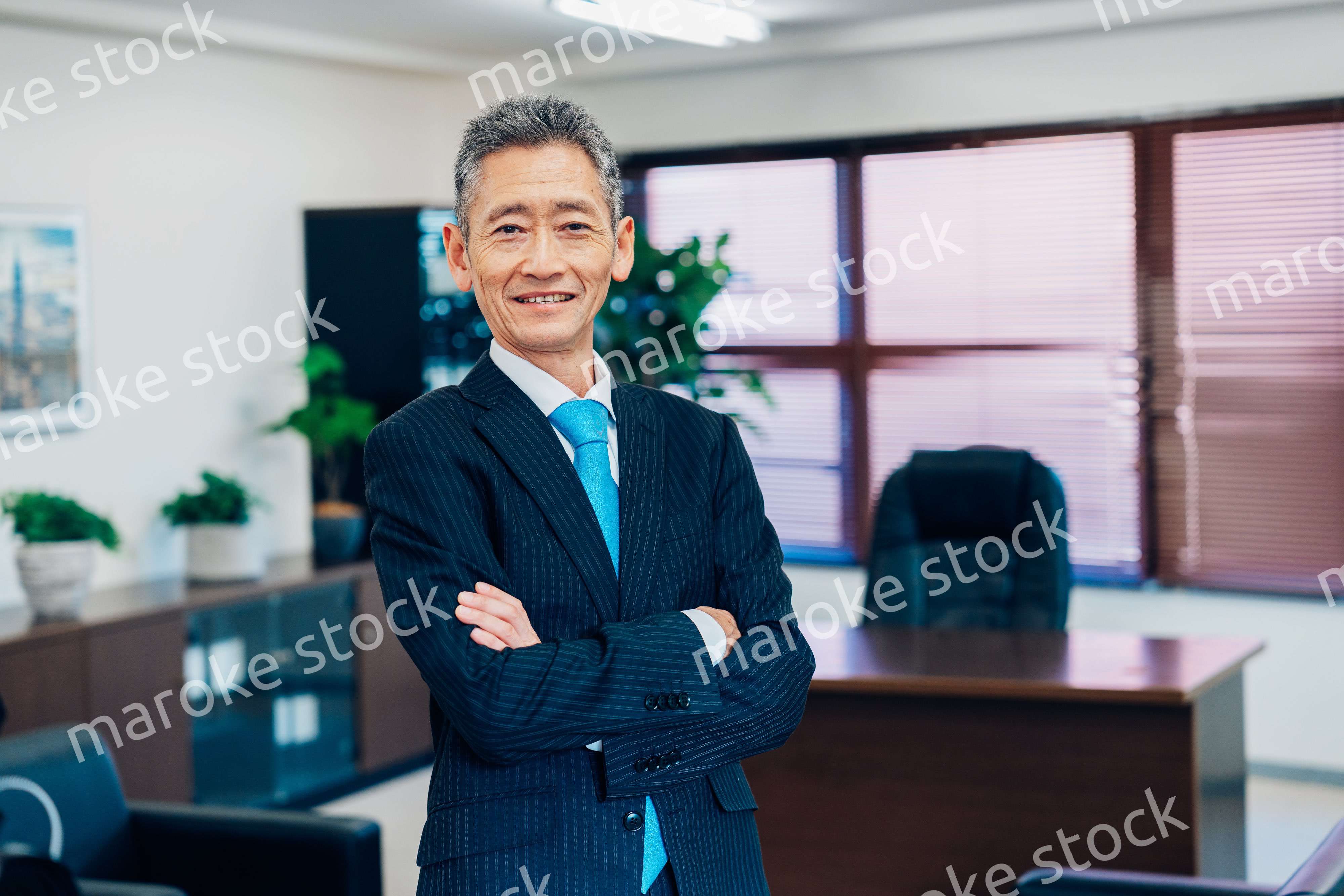 役員室で腕を組む経営者
