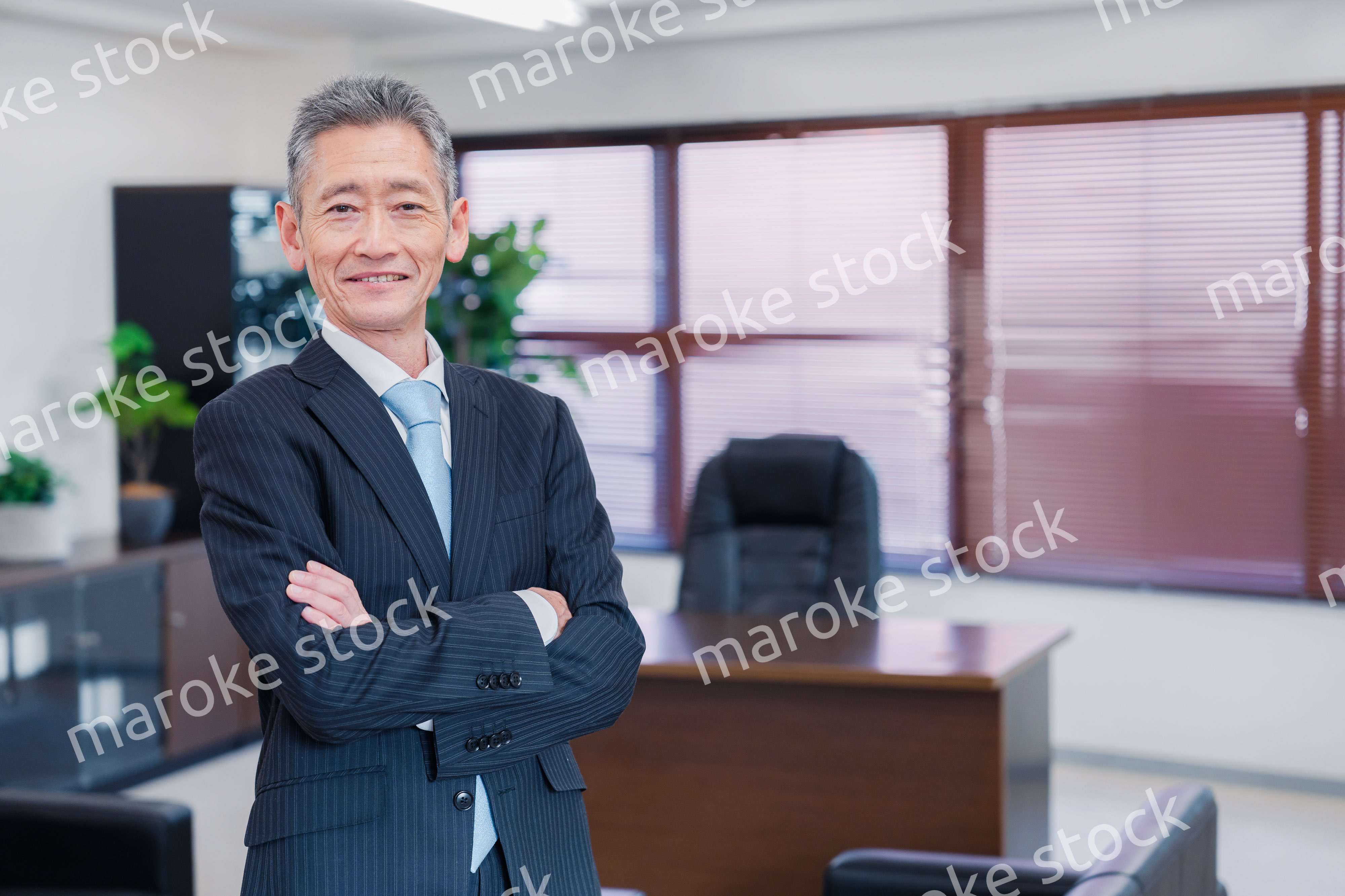 役員室で腕を組む経営者