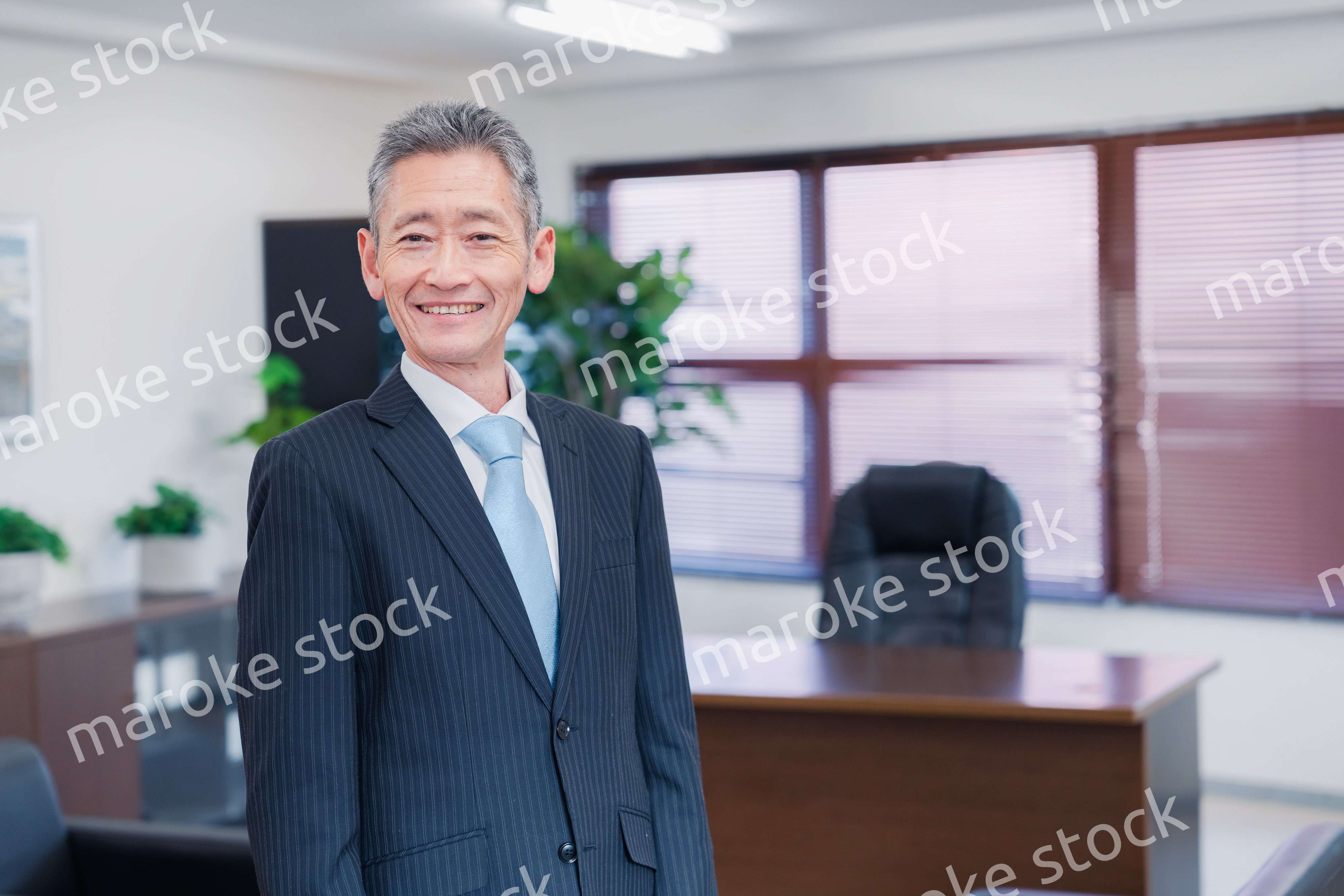 役員室で腕を組む経営者
