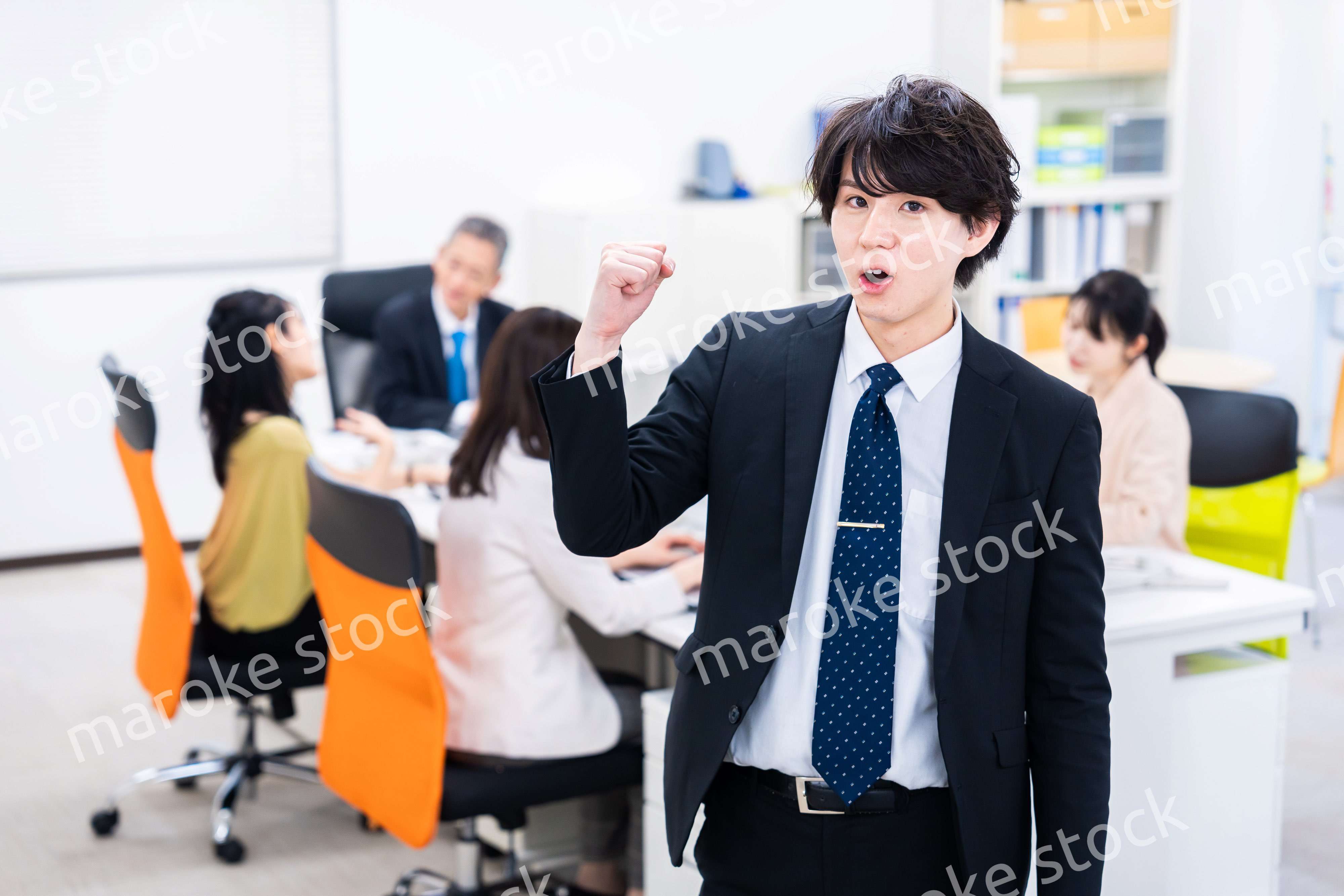 笑顔でガッツポーズをする若いビジネスマン