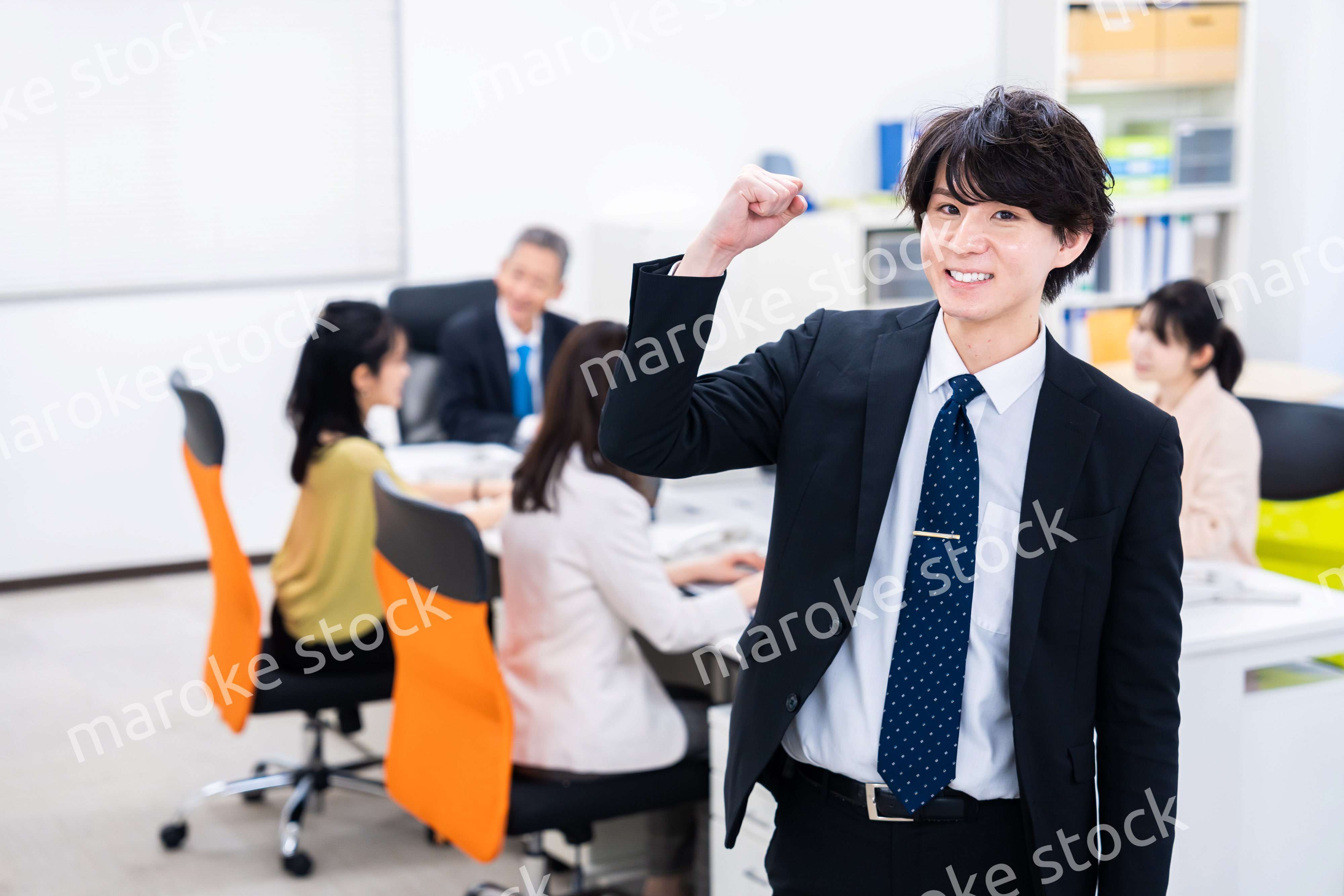 笑顔でガッツポーズをする若いビジネスマン