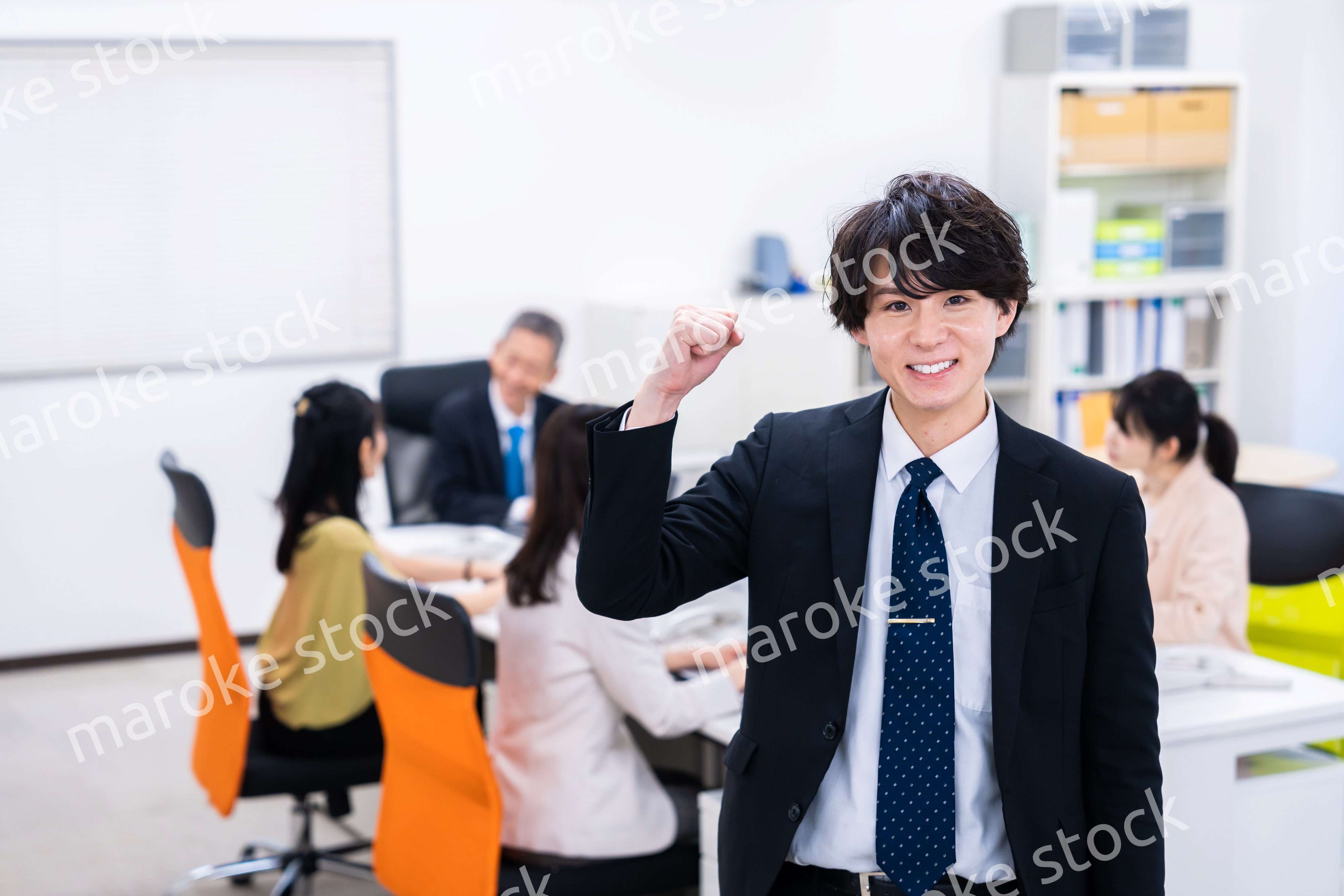 笑顔でガッツポーズをする若いビジネスマン