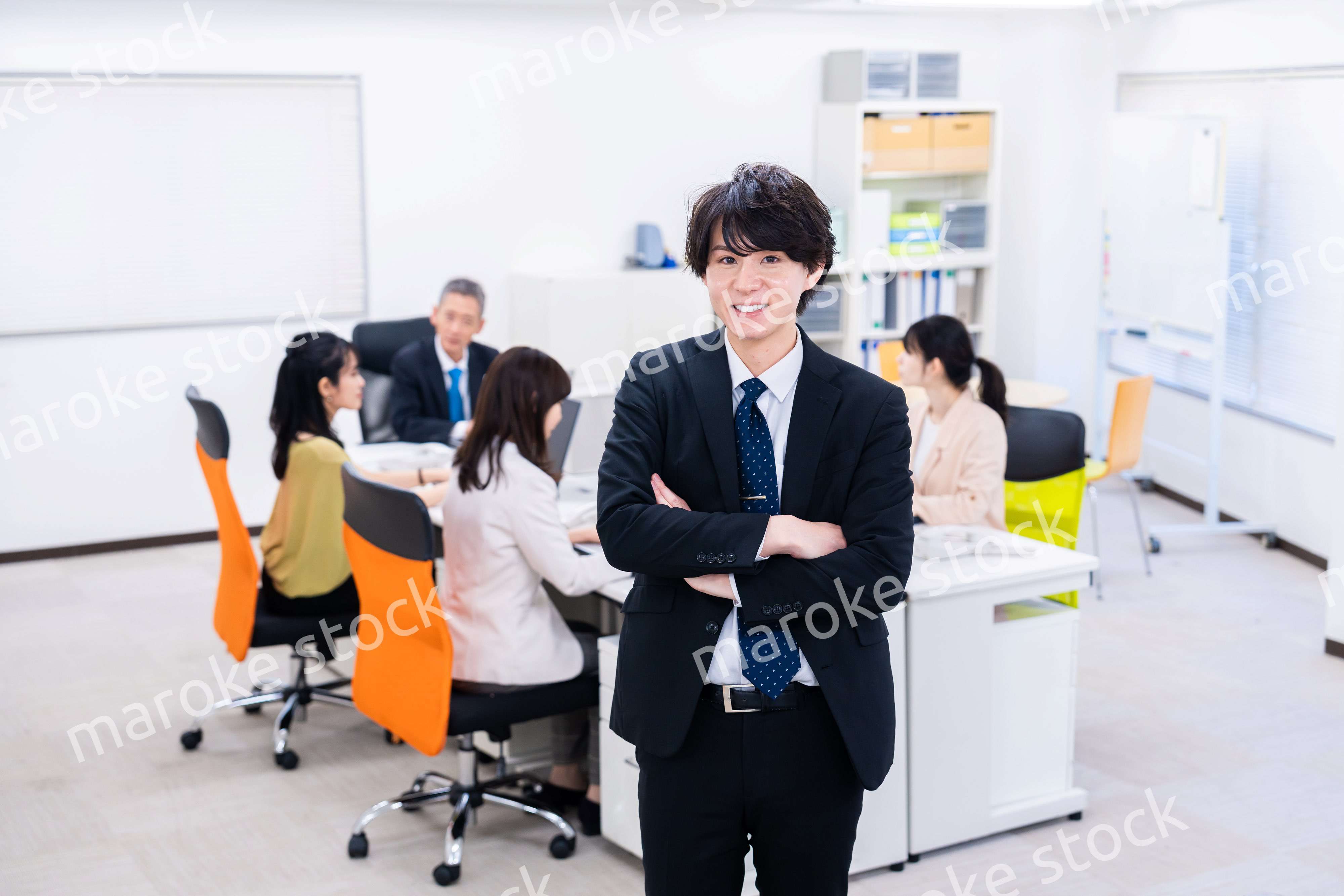 笑顔で腕を組む若いビジネスマン