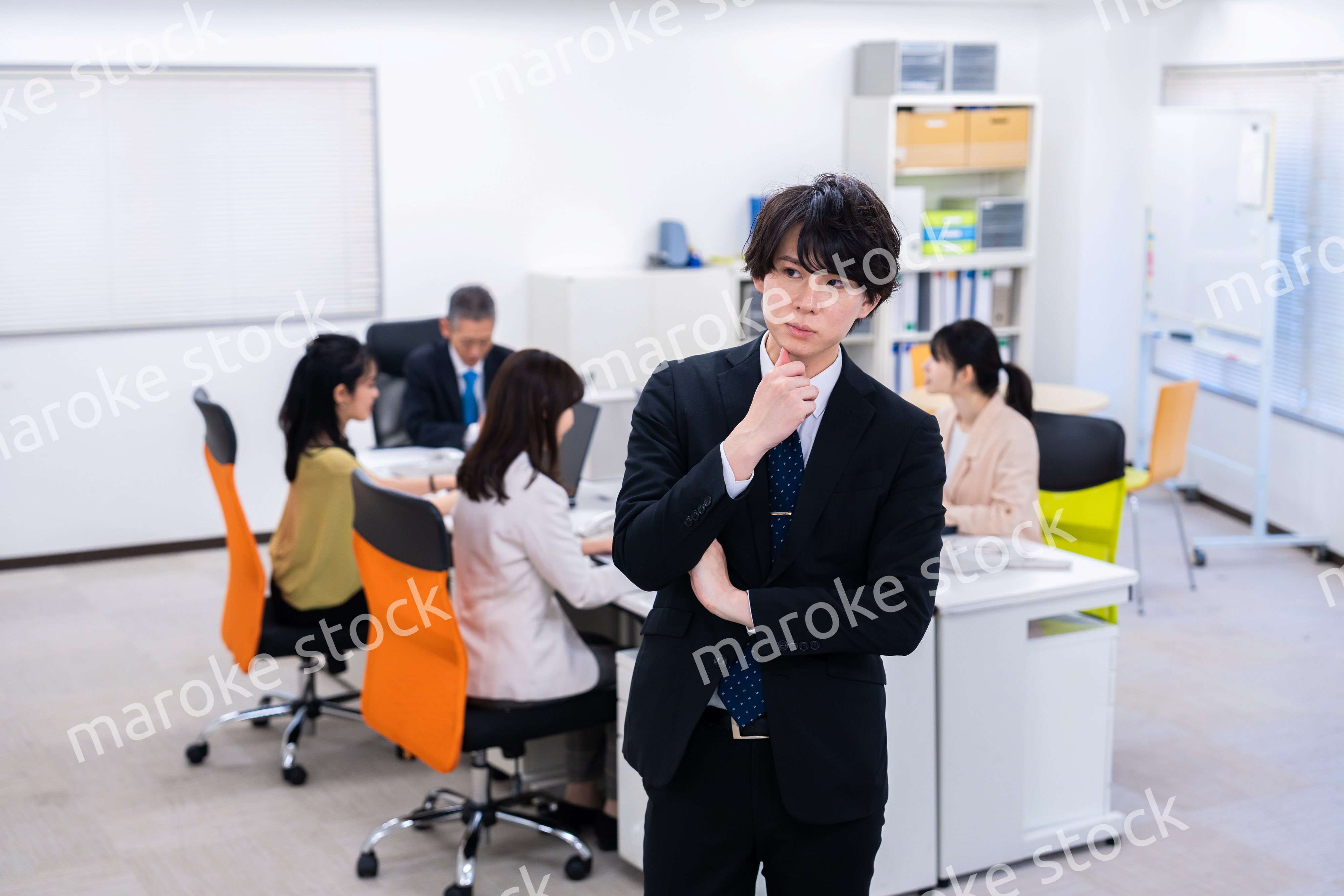 腕を組んで悩む若いビジネスマン