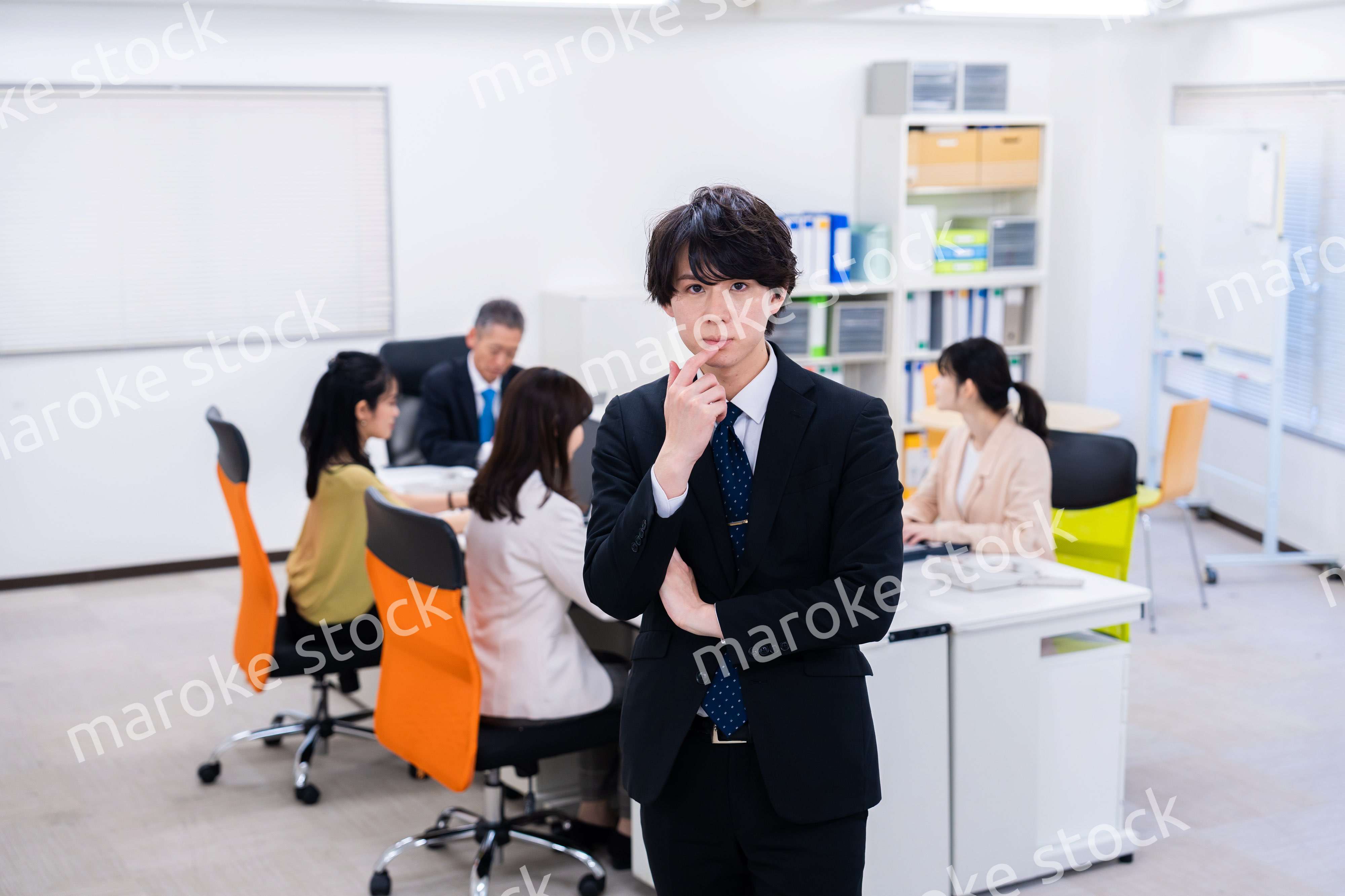 腕を組んで悩む若いビジネスマン