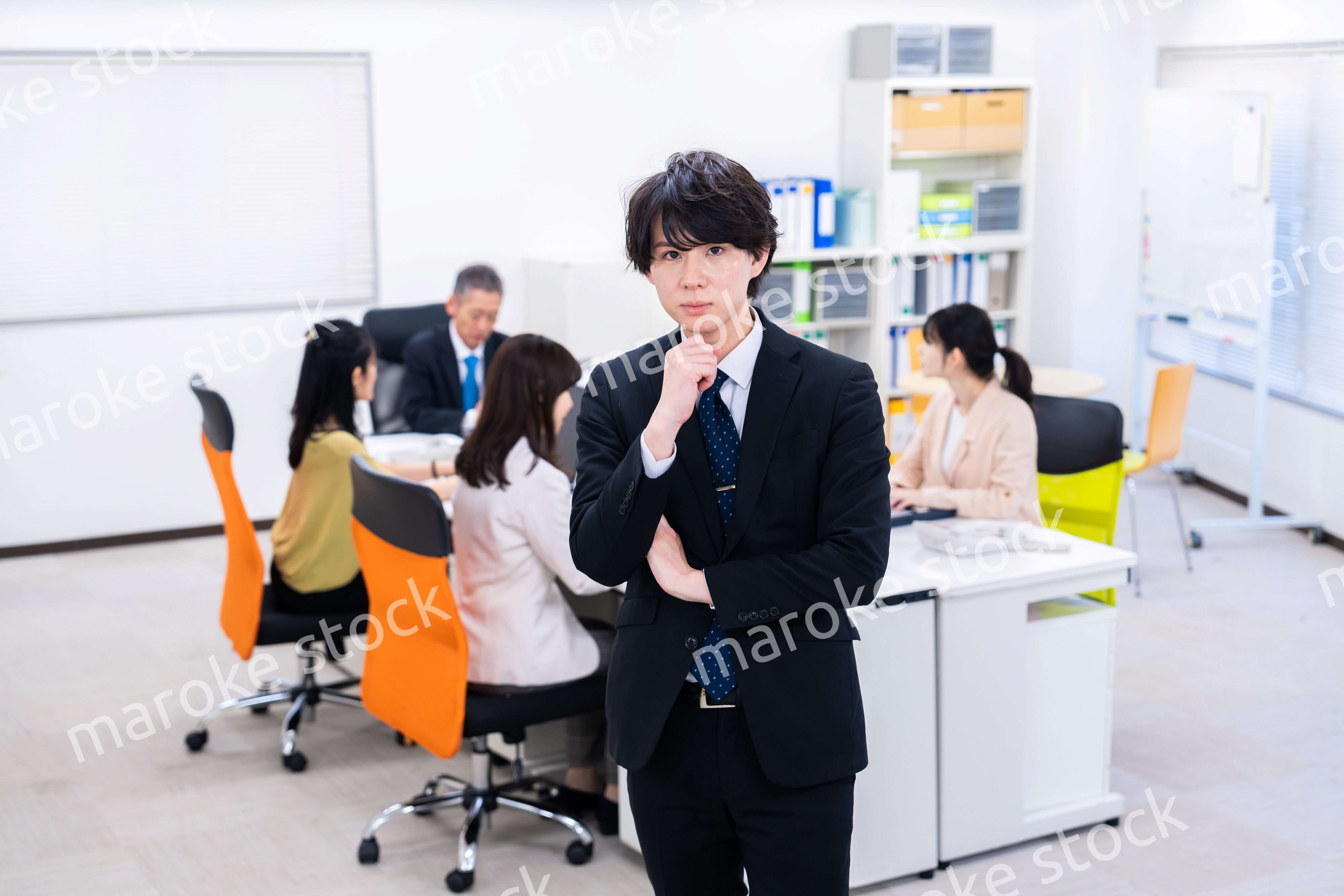 腕を組んで悩む若いビジネスマン