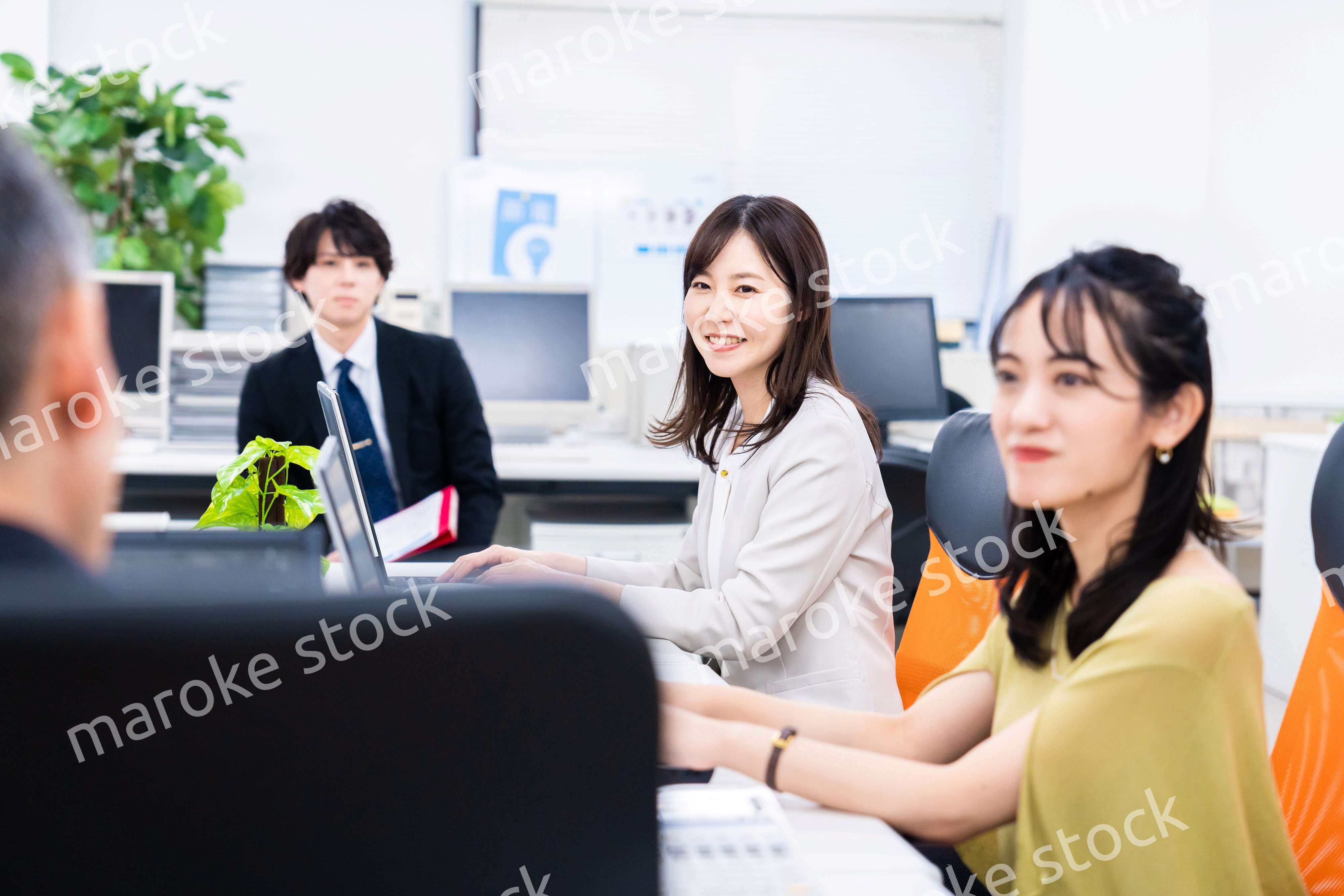 楽しくオフィスで仕事をするスタッフ