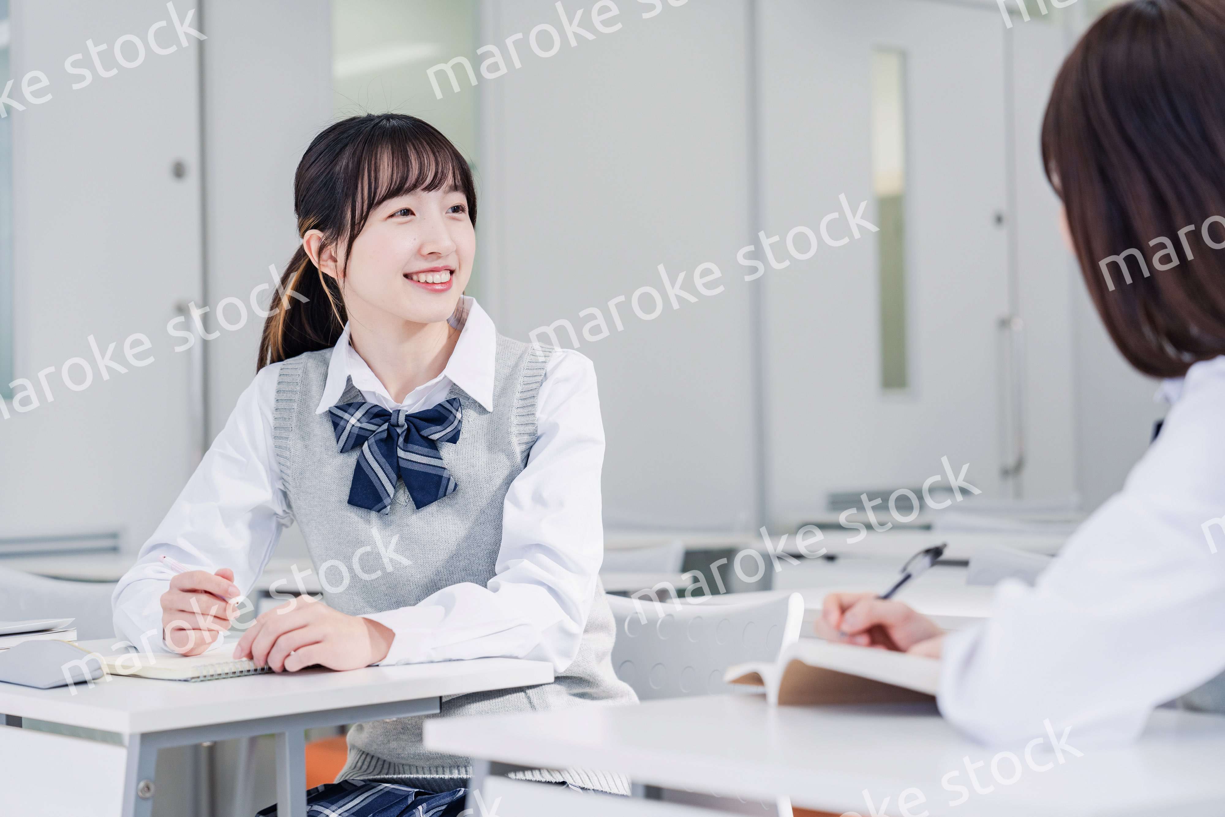 教室で休み時間に話す女子高生