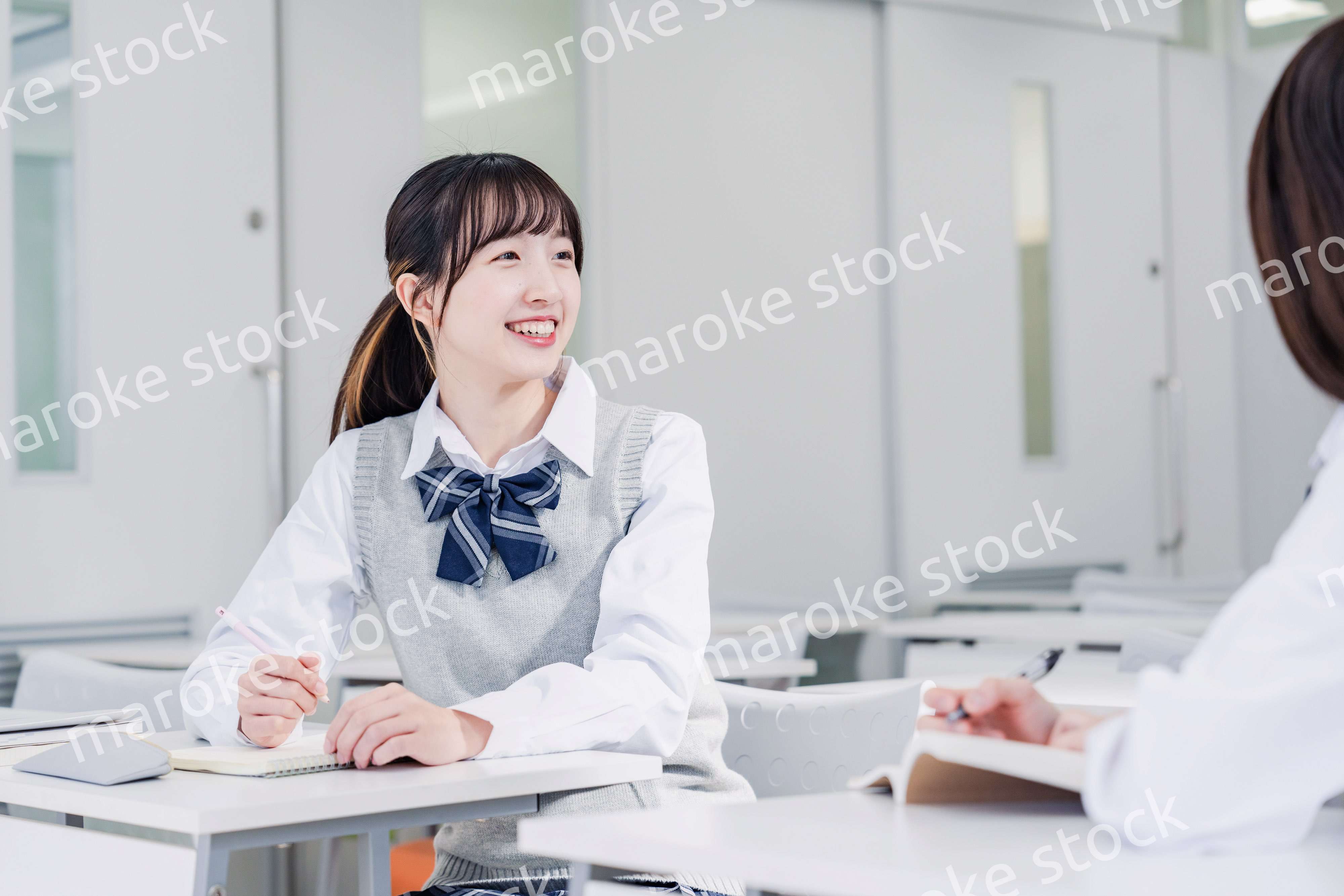 教室で休み時間に話す女子高生