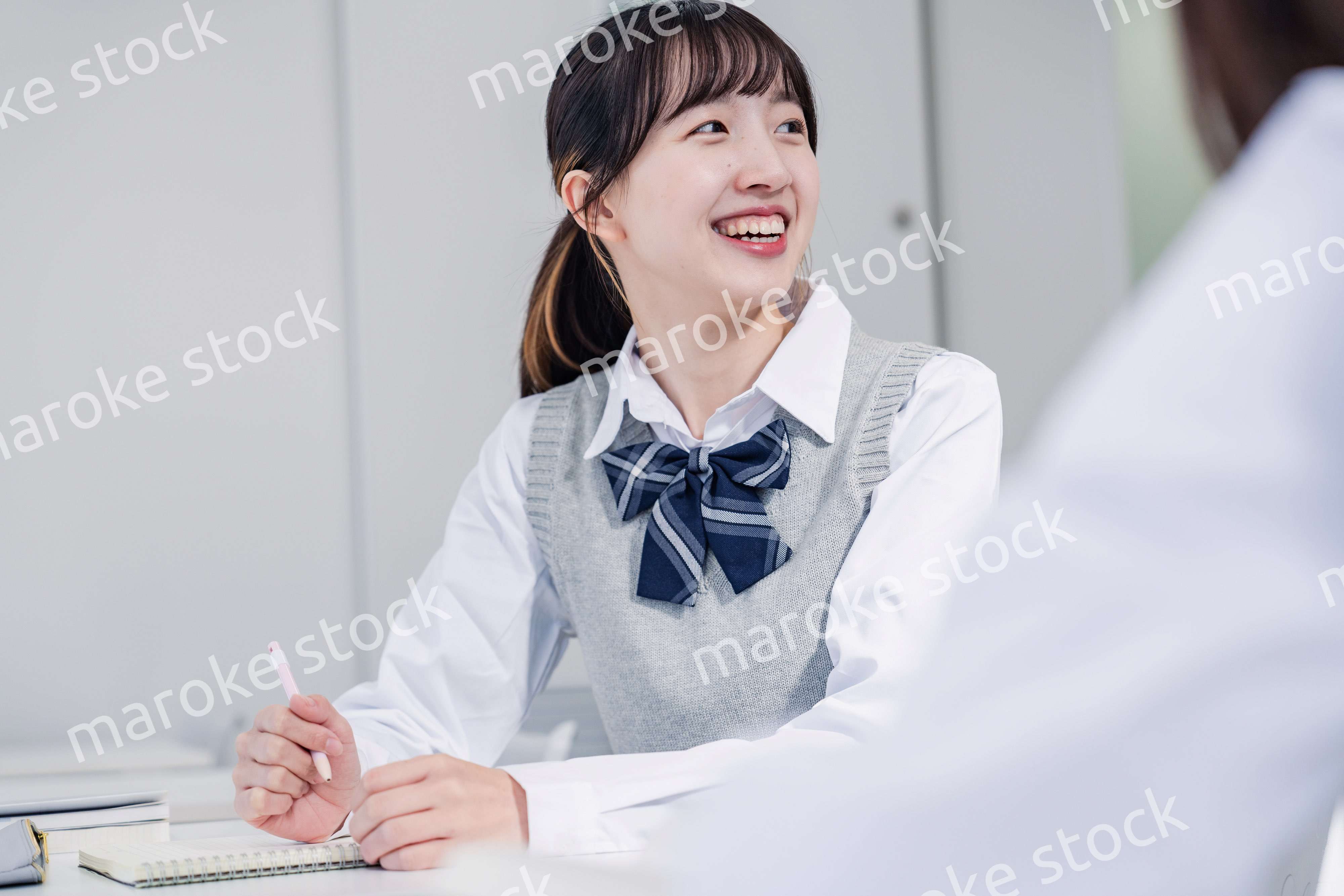 教室で休み時間に話す女子高生