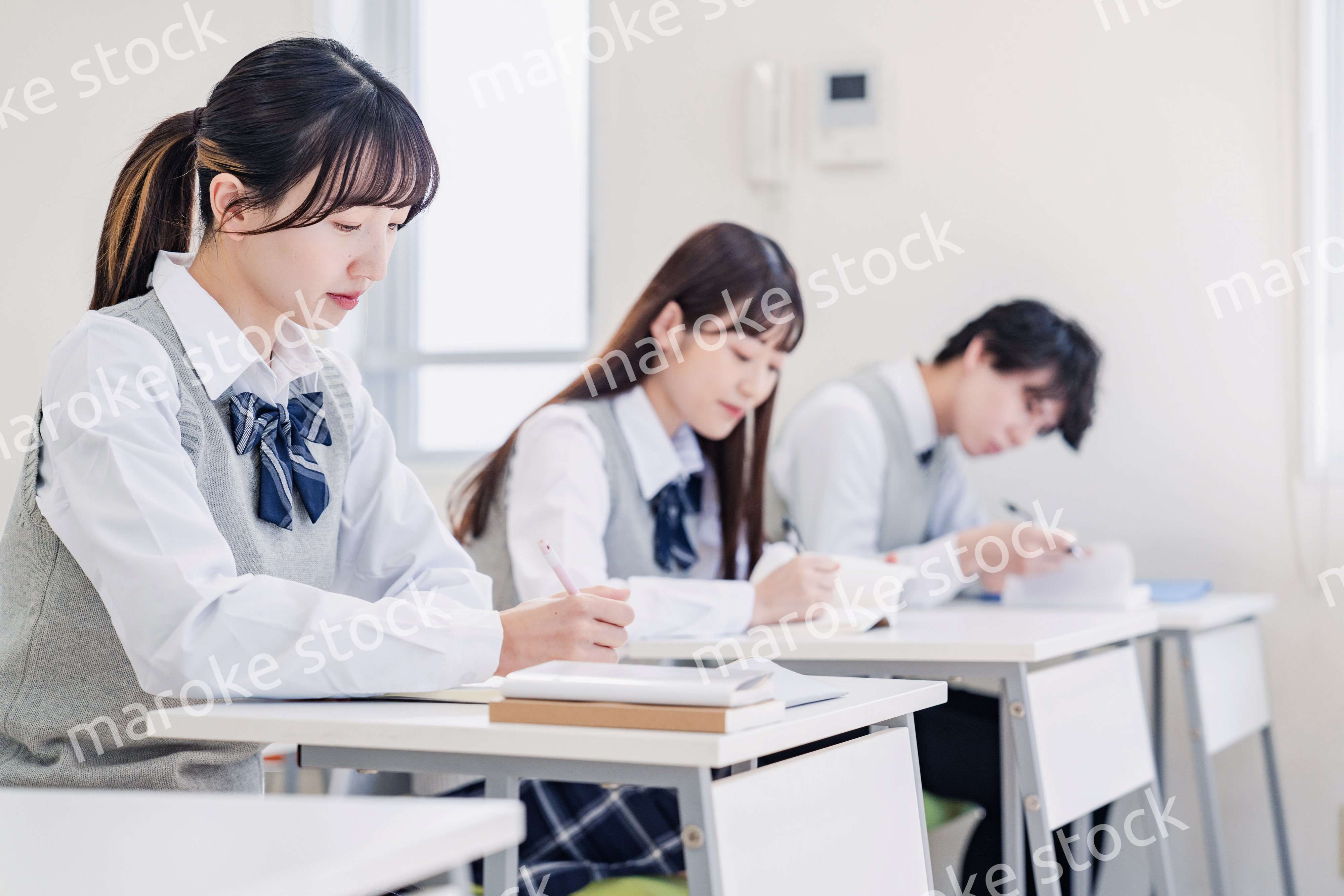 集中してノートを取る高校生